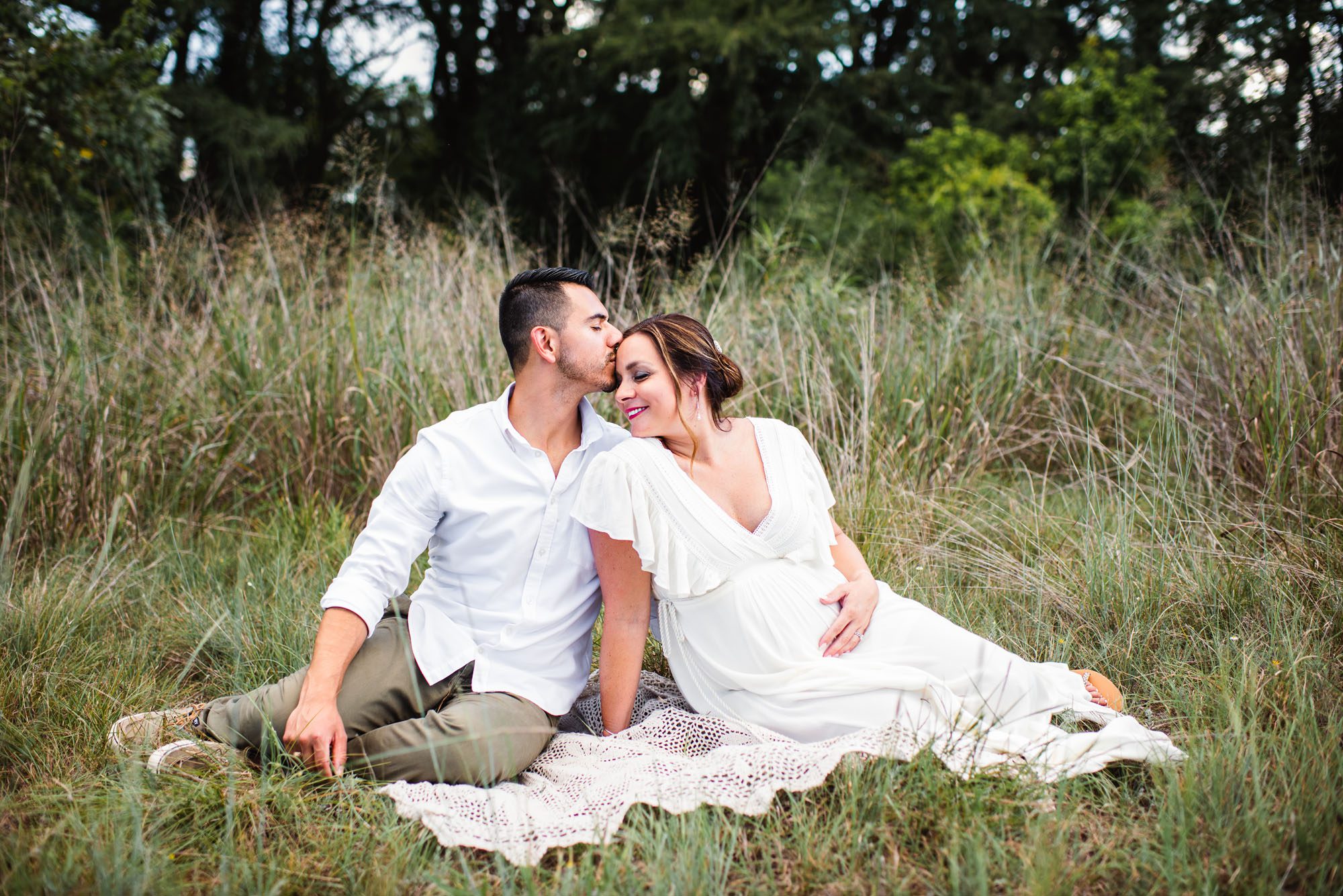 Pregnant couple sitting on blanket in a field, San Antonio maternity photographer