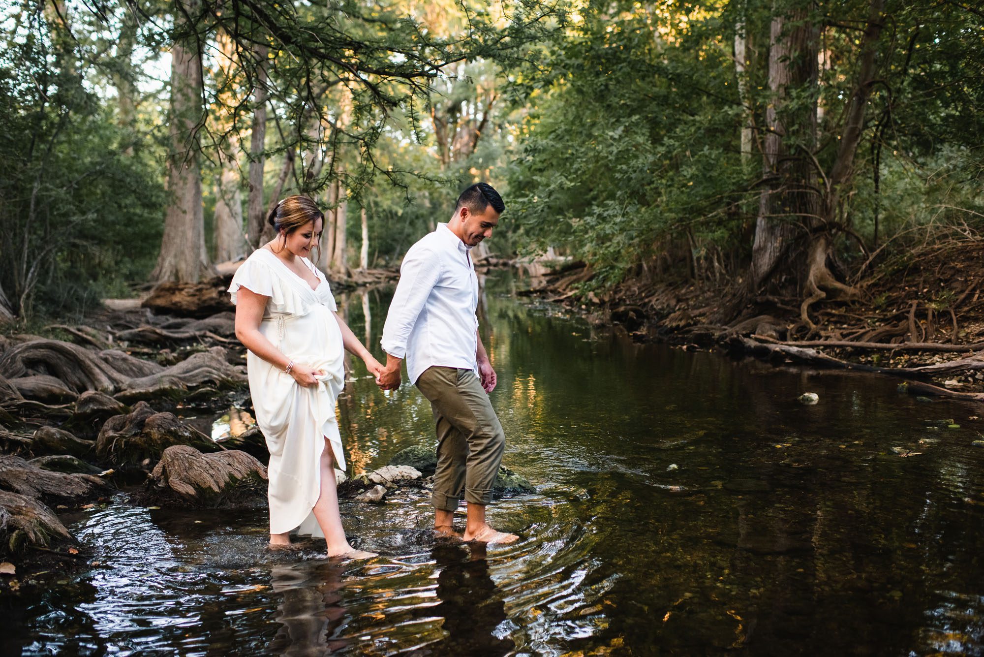 Pregnant couple walking into creek, San Antonio maternity photographer