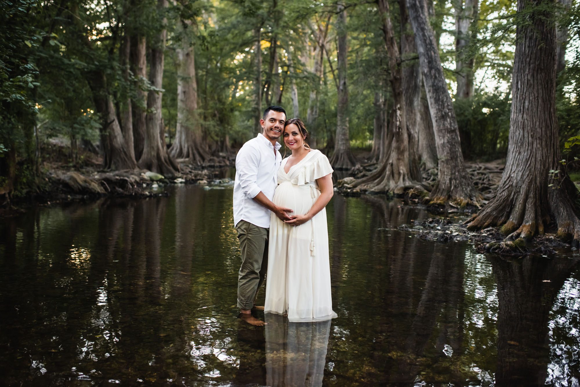 San Antonio lifestyle maternity photographer, pregnant couple standing in creek