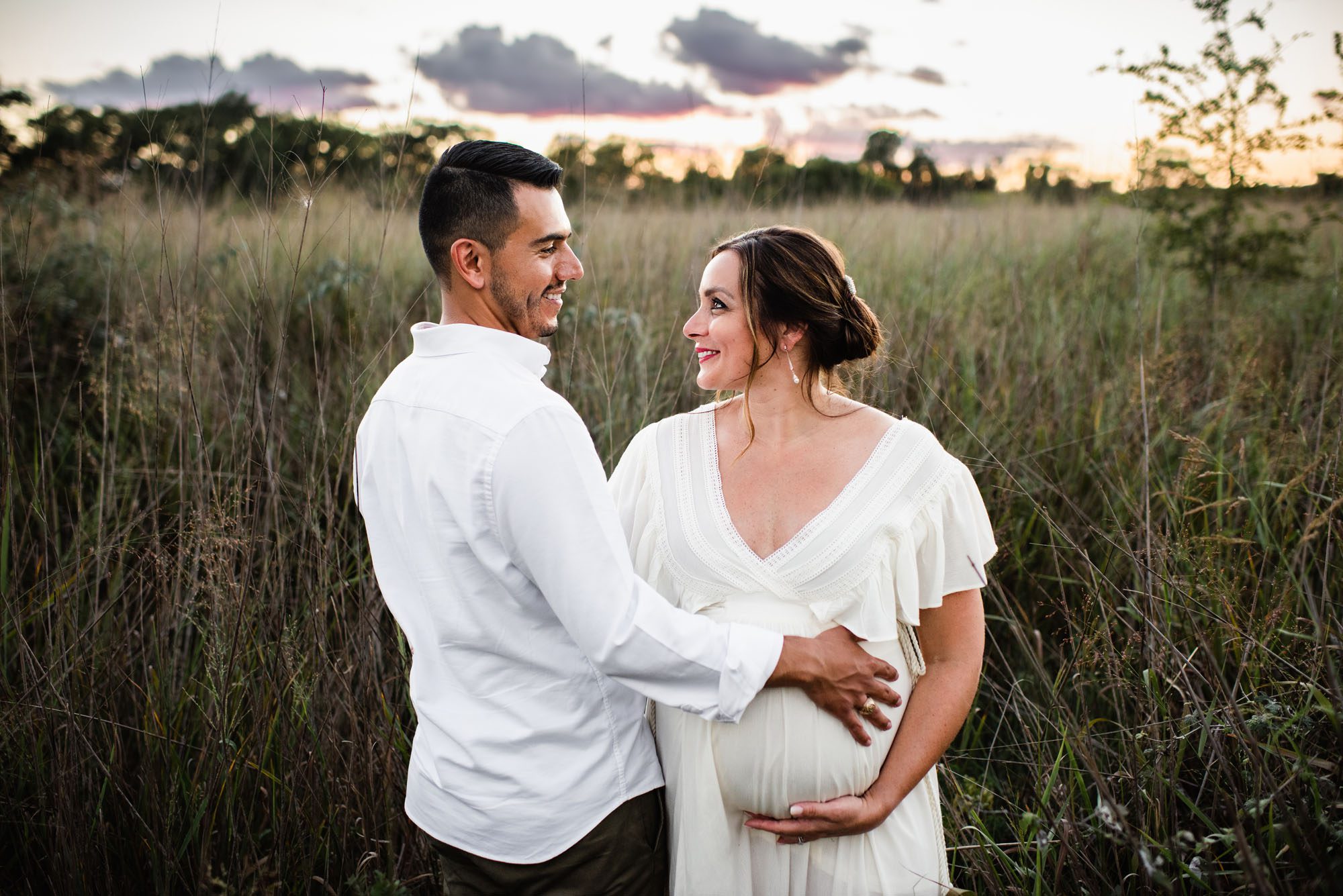 San Antonio Maternity Photographer, couple smiling at each other in the tall grass