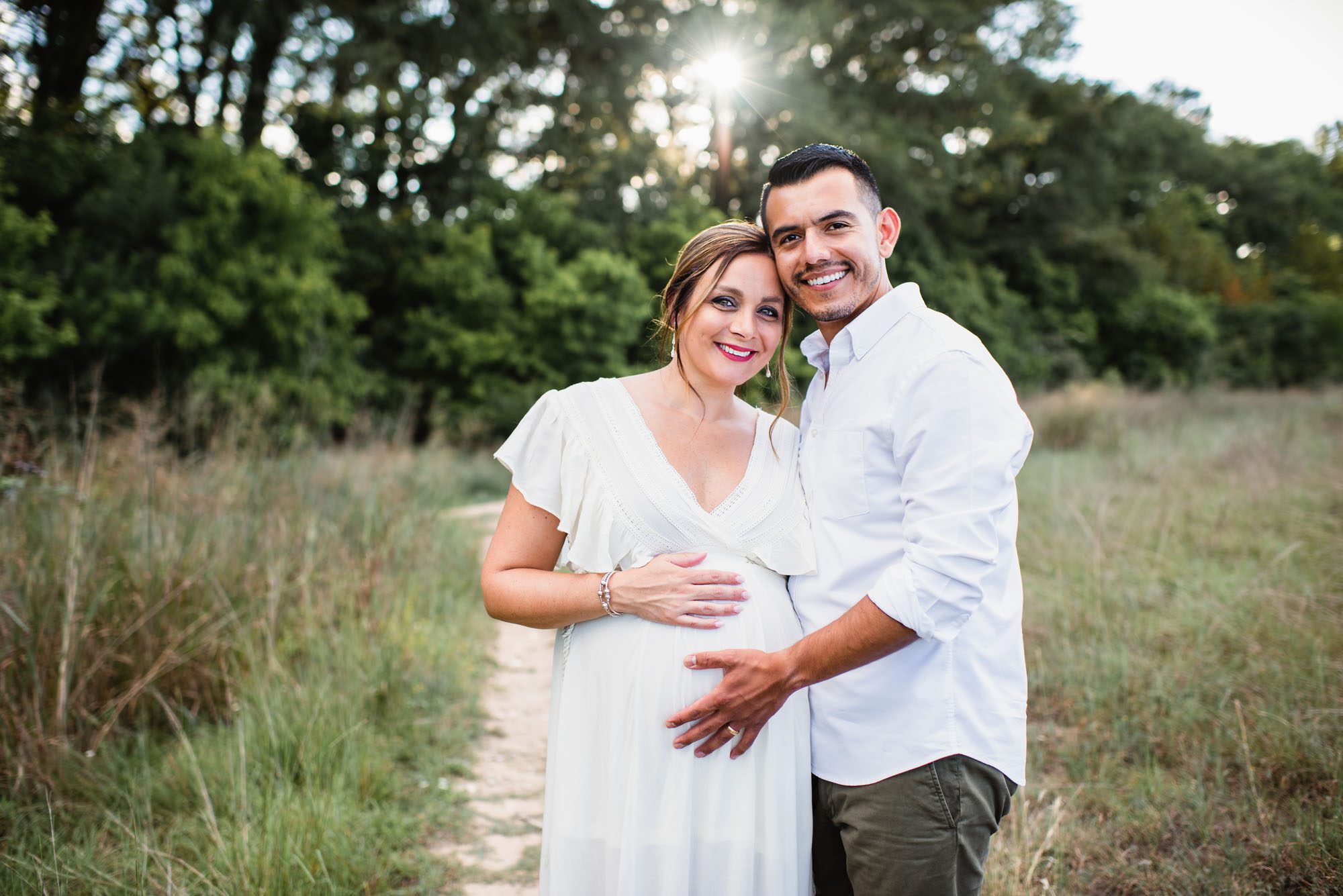 Pregnant couple standing in a field at sunset, San Antonio maternity photographer