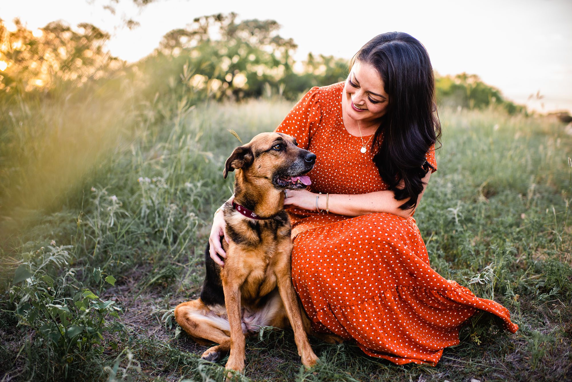 Woman petting her dog in a field, San Antonio family photographer