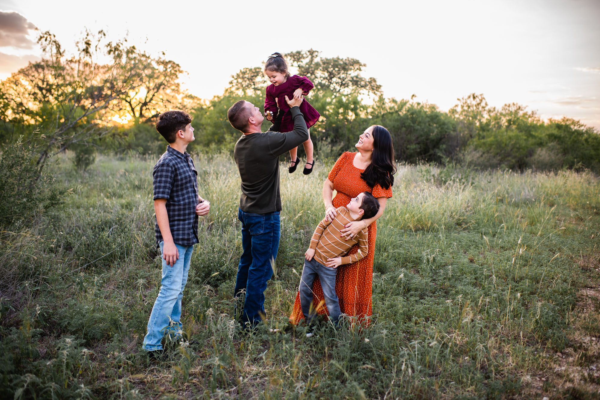 Family playing with little girl in a field, San Antonio family photographer