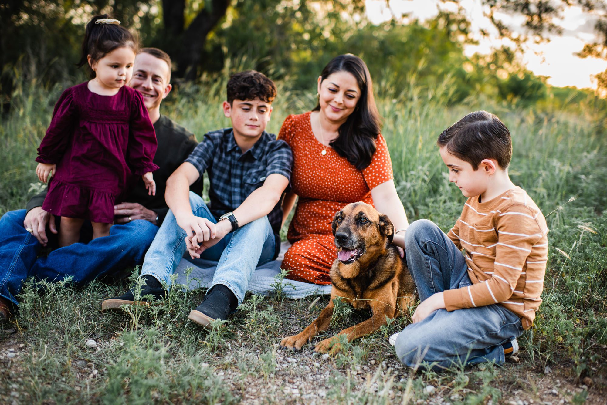 Family sitting with their dog in a field, family photographer in San Antonio