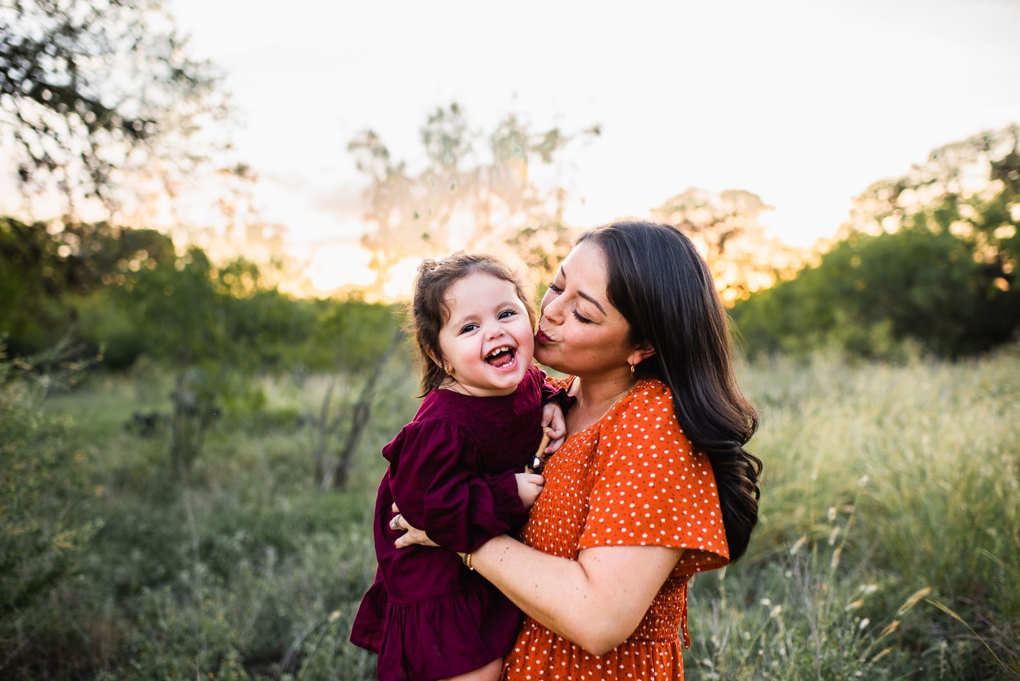 Mother kissing daughter's cheek, family photographer in San Antonio