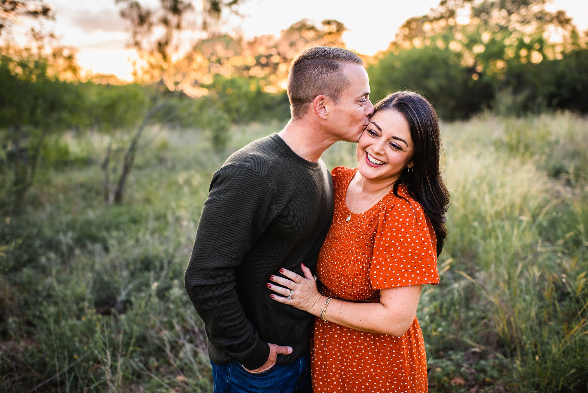 Husband kissing wife's cheek, family photographer in San Antonio