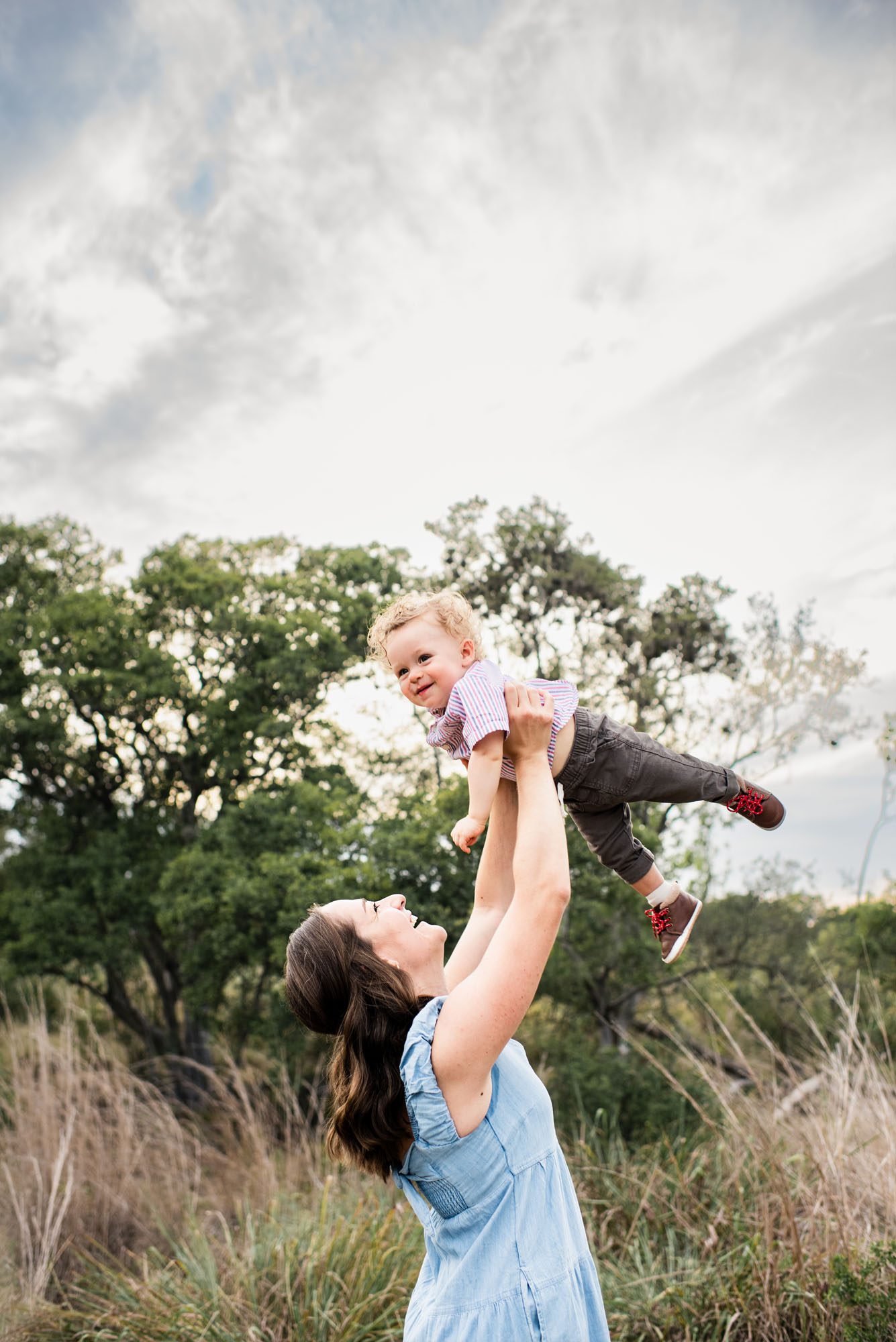 Mother holding up baby boy in a field, San Antonio Lifestyle Family Photographer