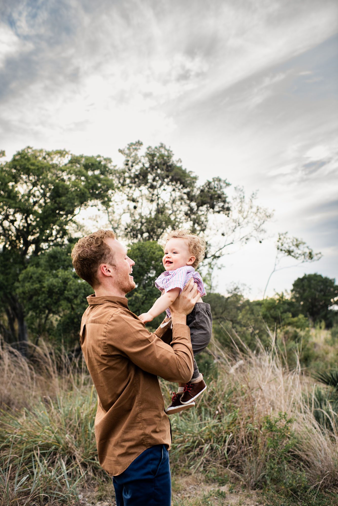 Father holding up baby boy in a field, San Antonio Family Photographer