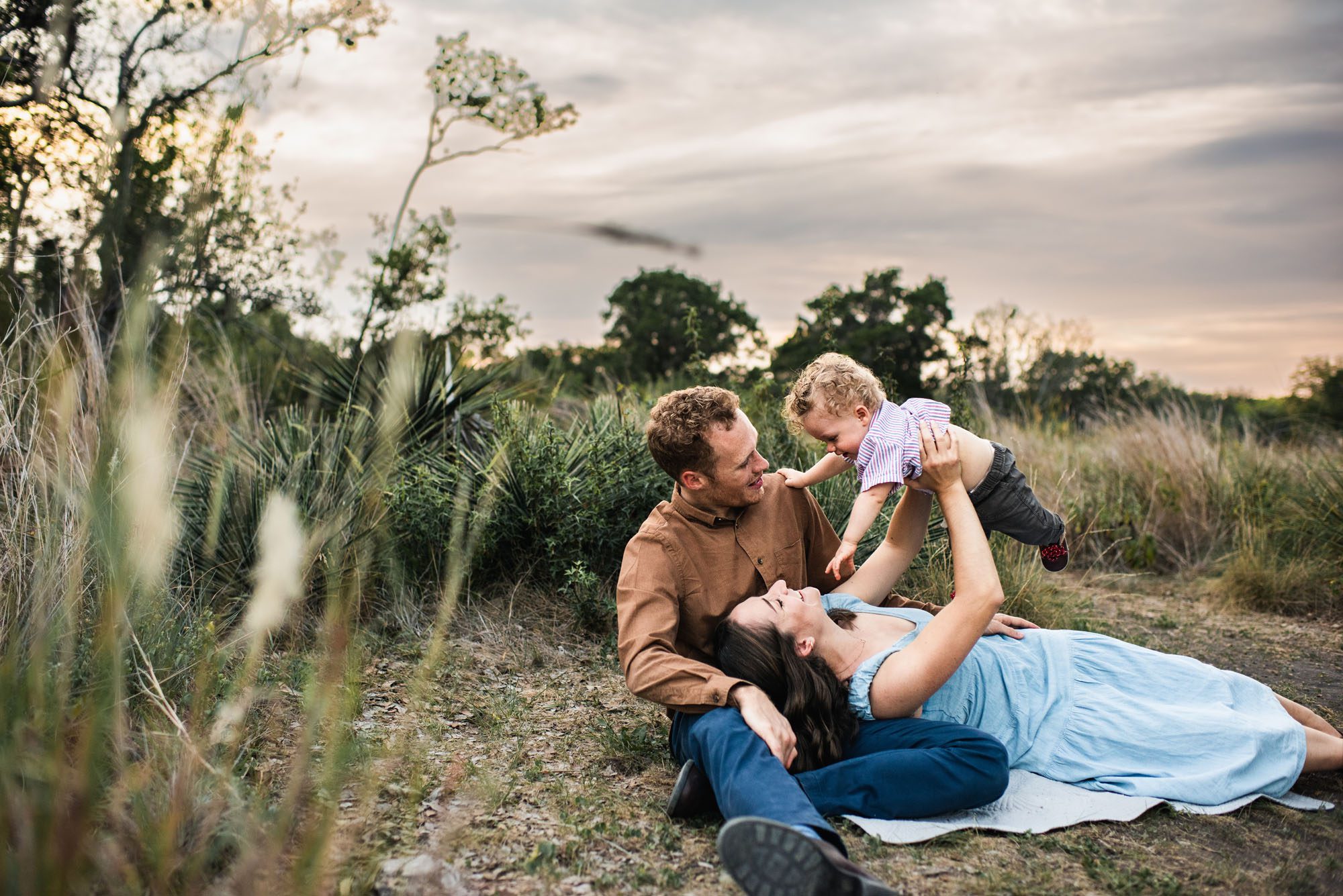 Family with baby boy sitting on blanket in a field, San Antonio Lifestyle Photographer