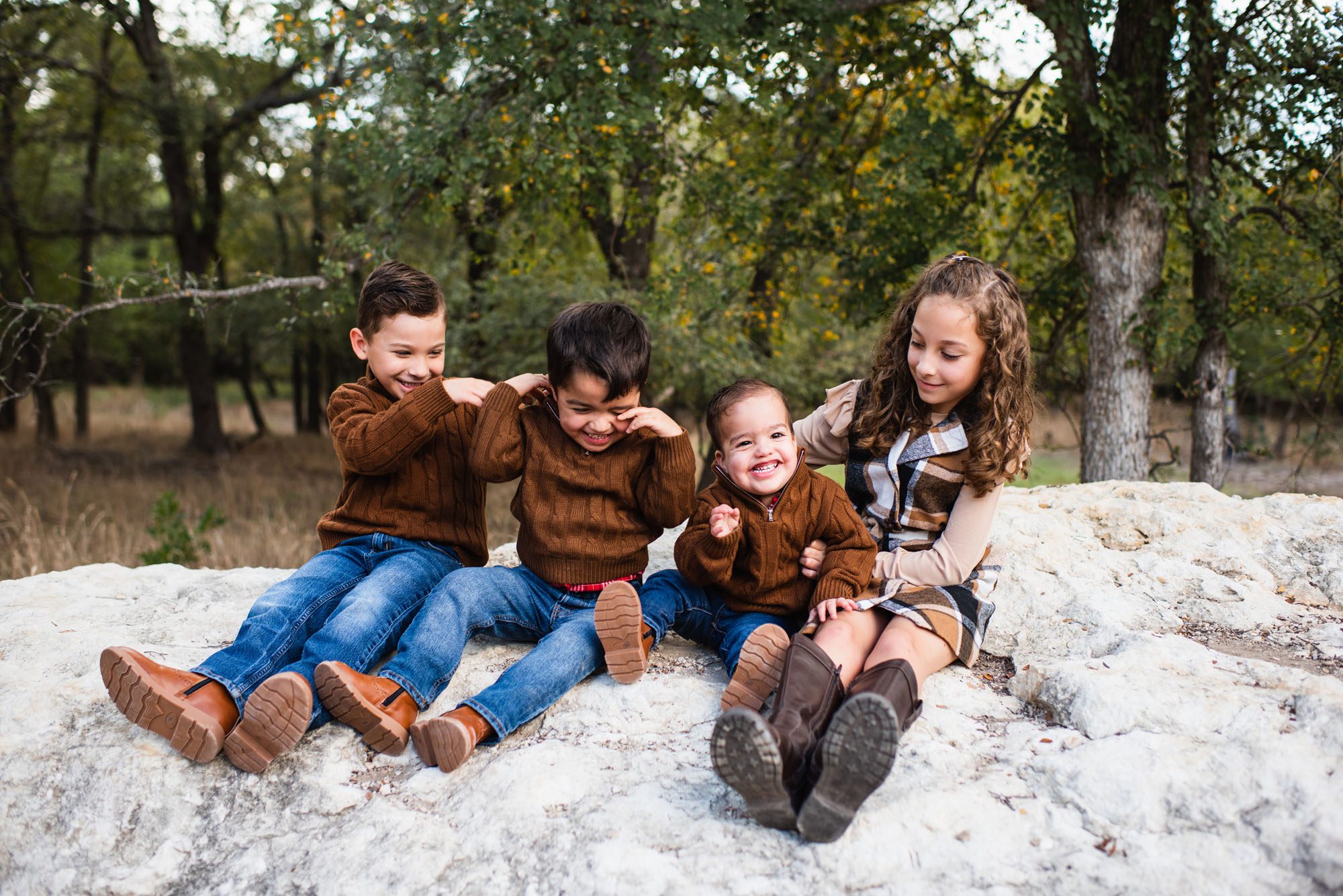 Kids sitting on rock together and laughing, San Antonio Family Photographer