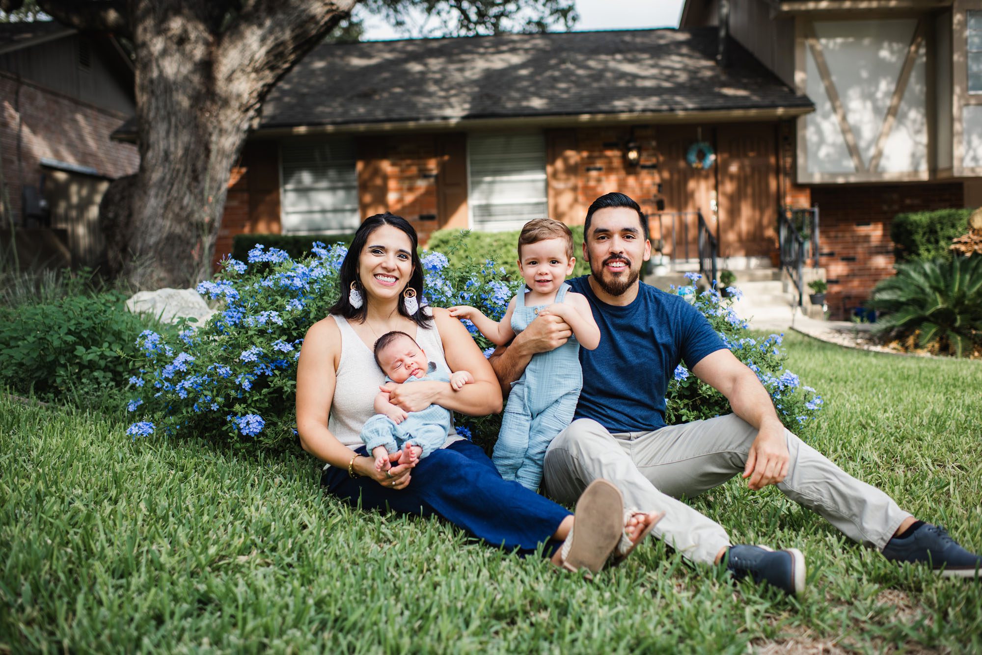 Family sitting in front yard with newborn baby, San Antonio newborn photographer