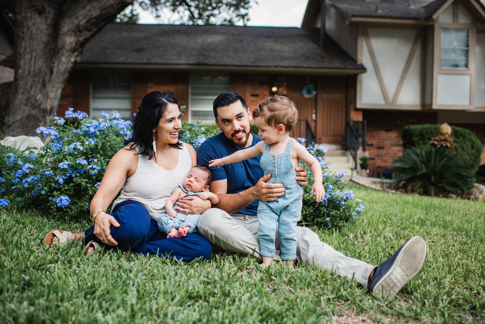 Family sitting in front yard with newborn baby, San Antonio newborn photographer