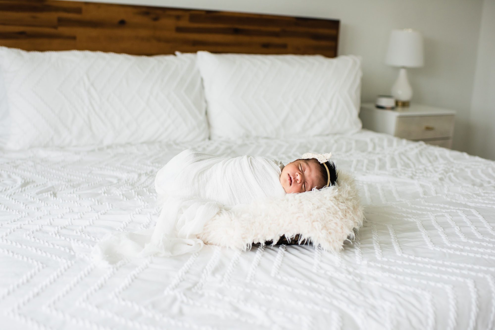 Newborn posed in basket on white bed, San Antonio Newborn Photographer