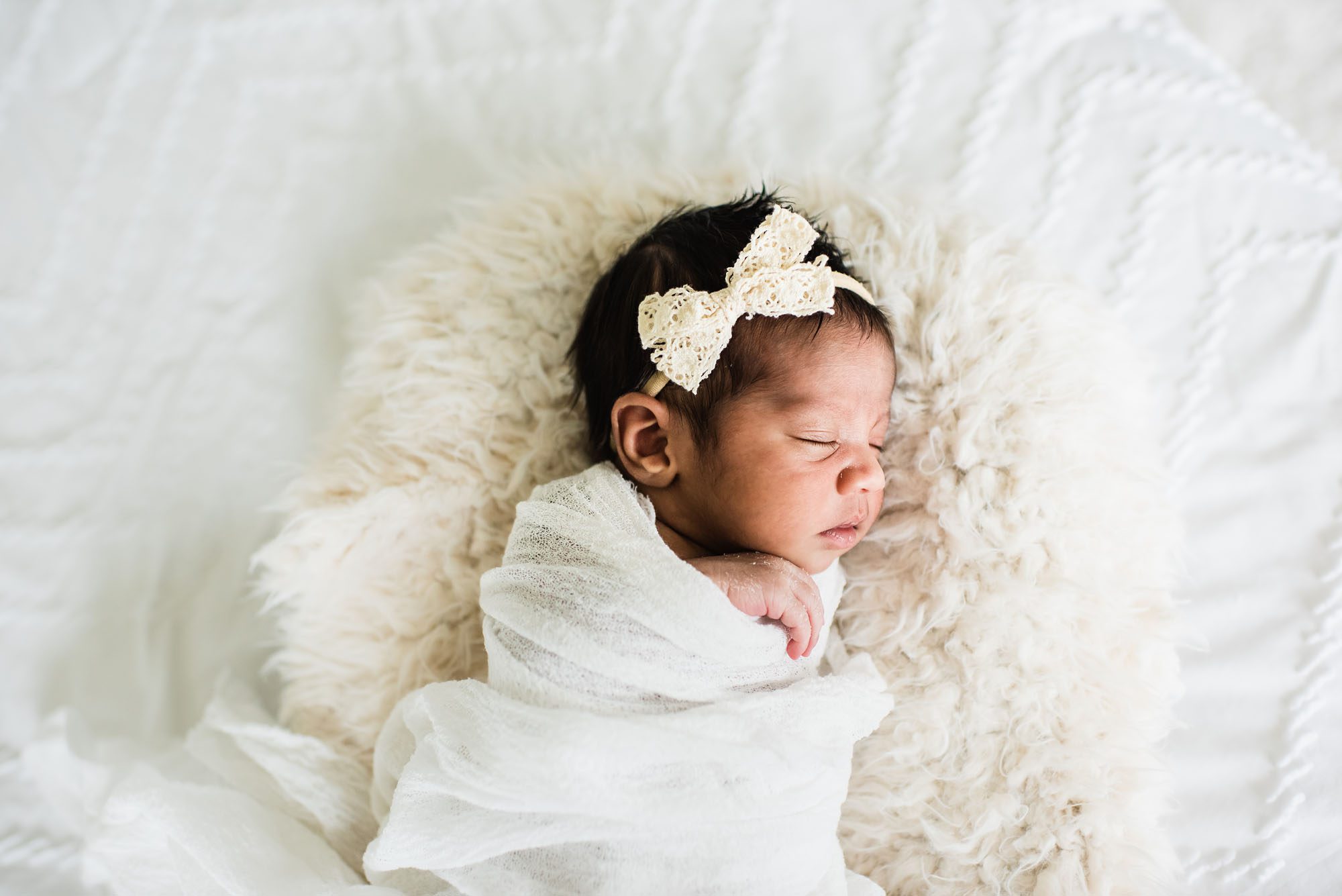 Newborn baby asleep in basket on white bed, San Antonio Newborn Photographer