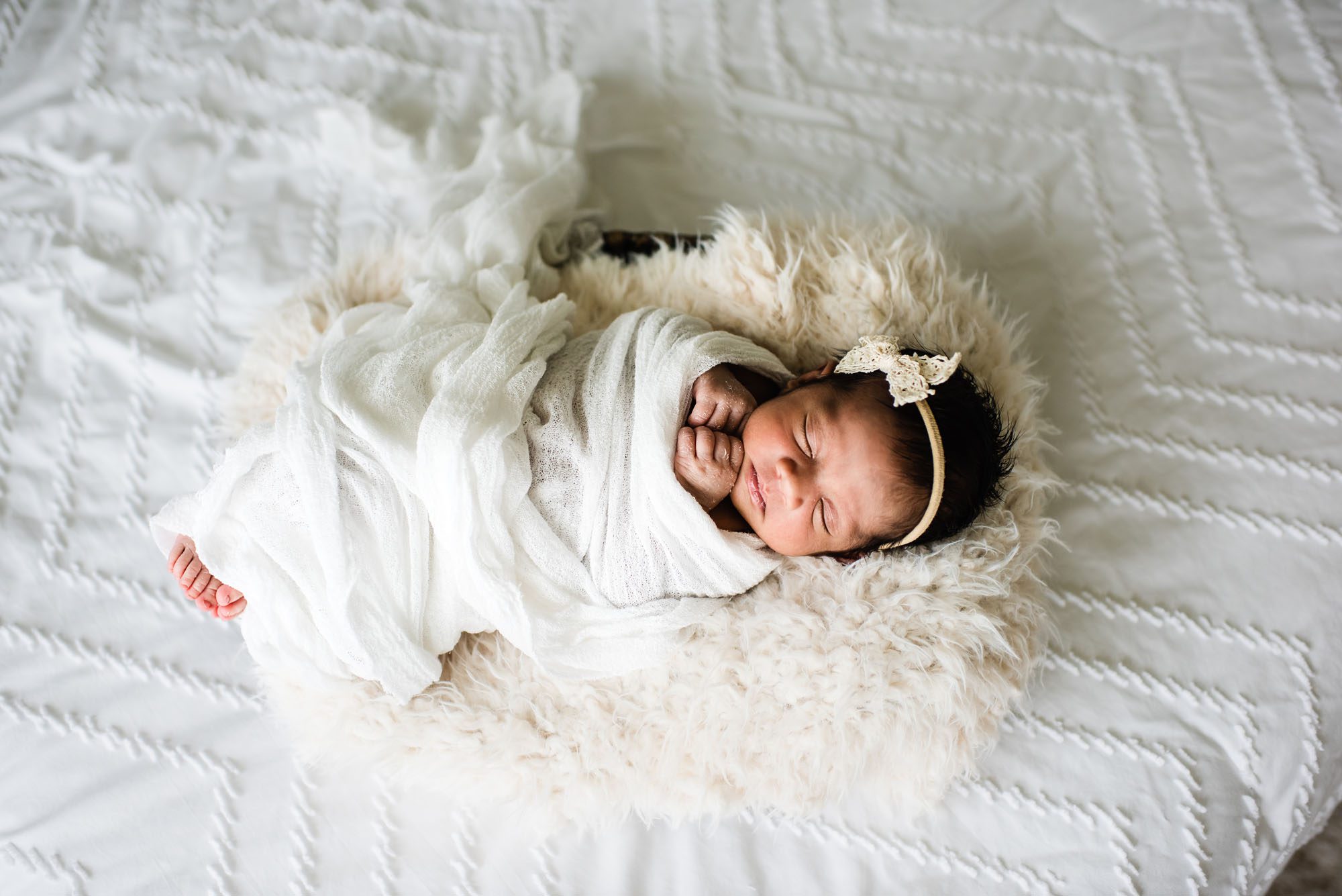 Newborn baby asleep in basket on white bed, San Antonio Newborn Photographer
