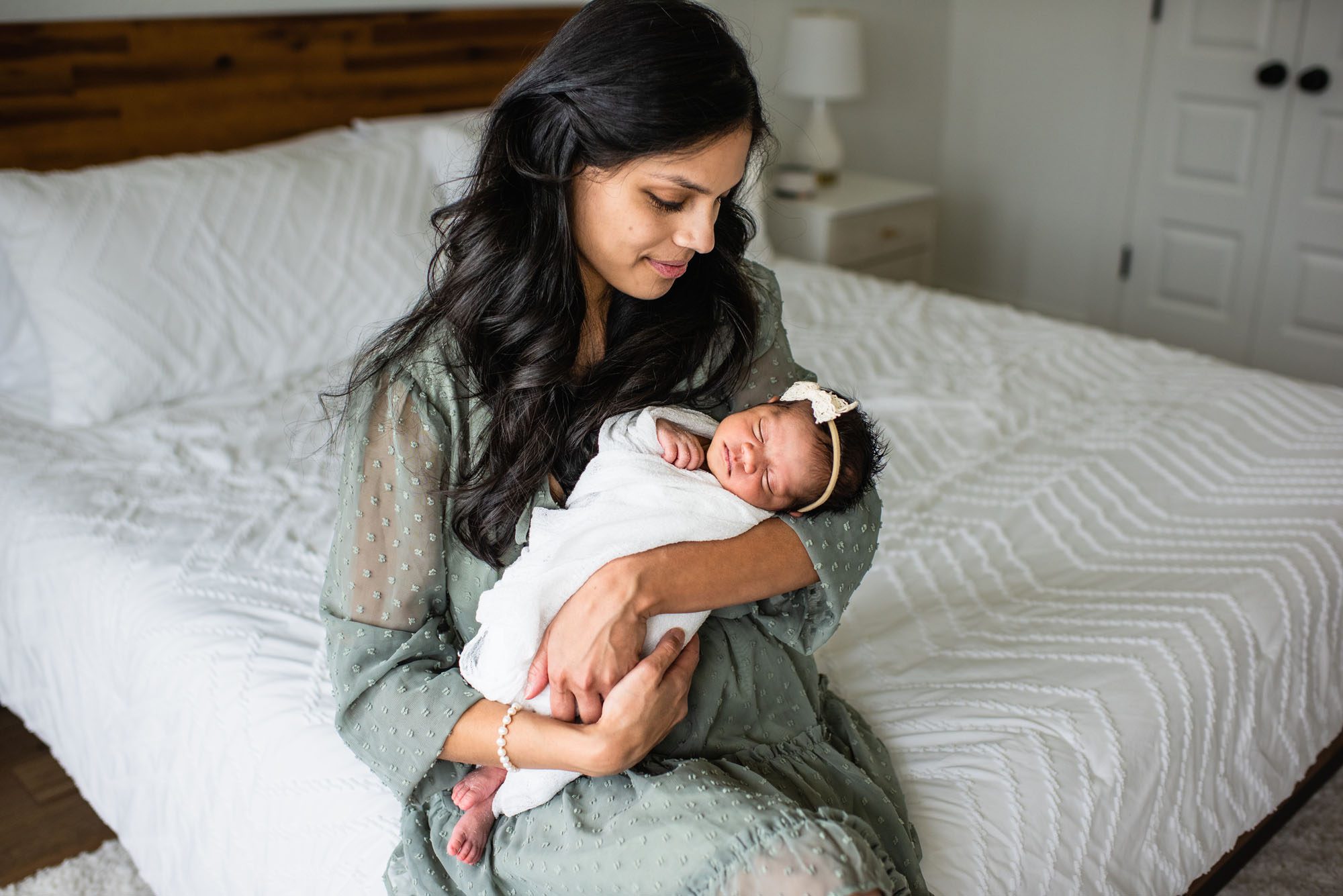 San Antonio Lifestyle Newborn Photographer, Mother in green dress holding newborn daughter