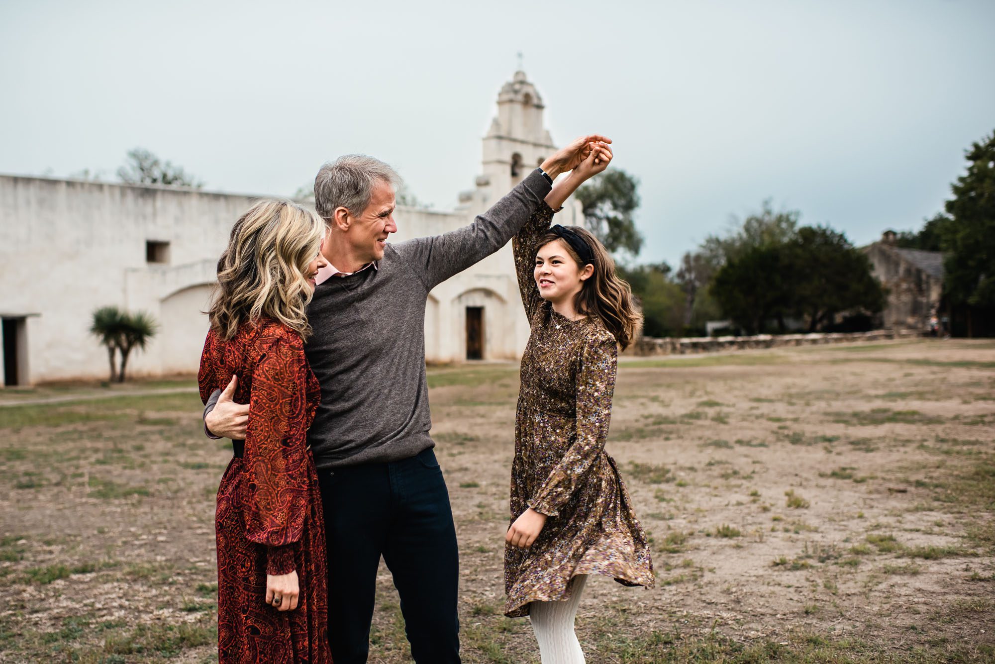 Father twirling daughter in front of San Antonio mission, San Antonio lifestyle photographer