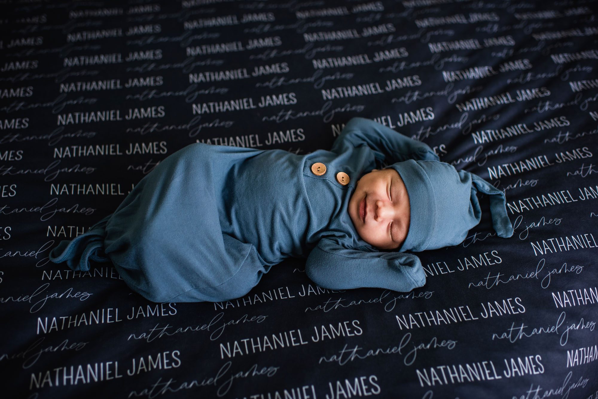 San Antonio Newborn Photographer, newborn baby smiling while sleeping on bed