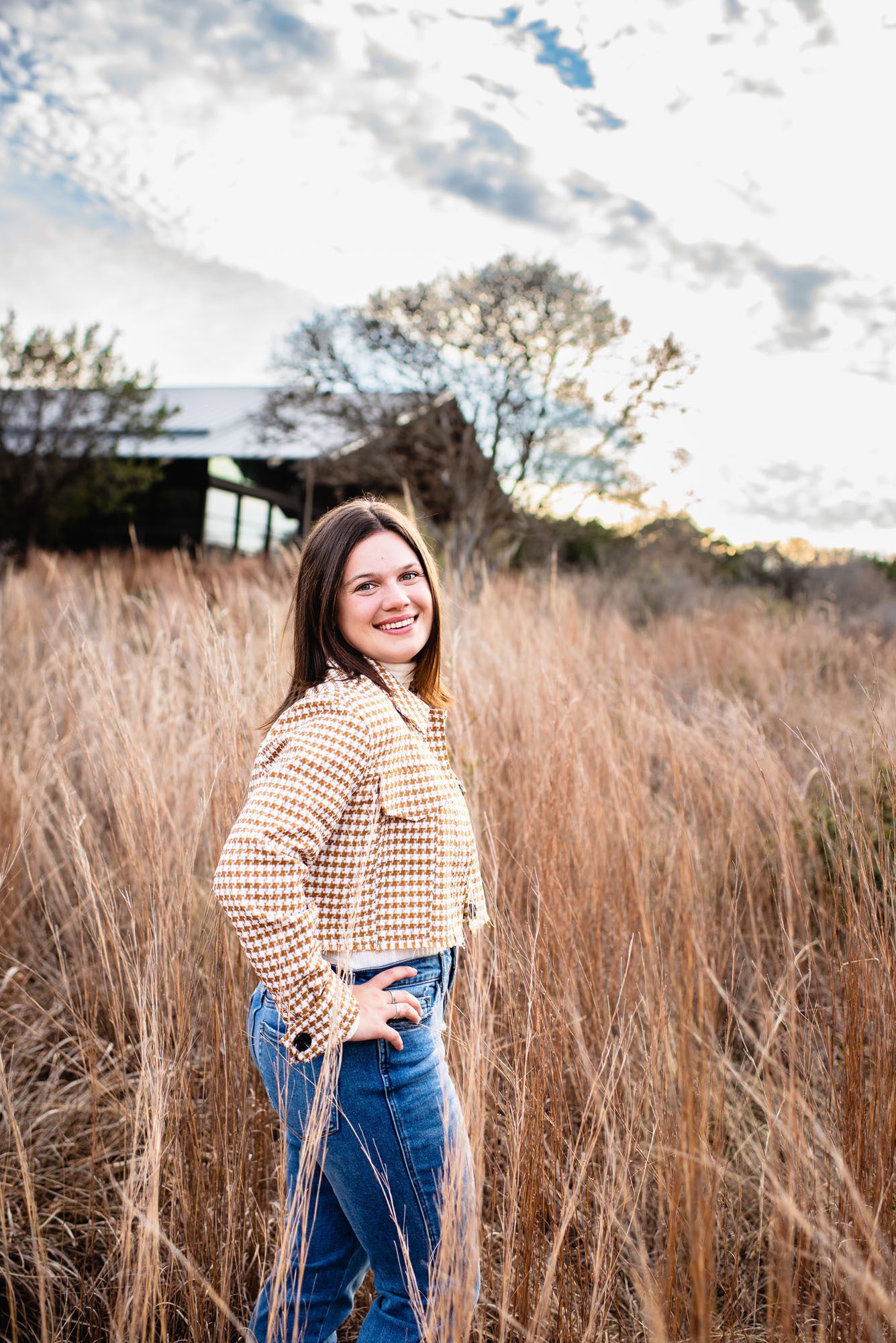 Senior girl standing among tall grasses in a field, San Antonio senior photographer