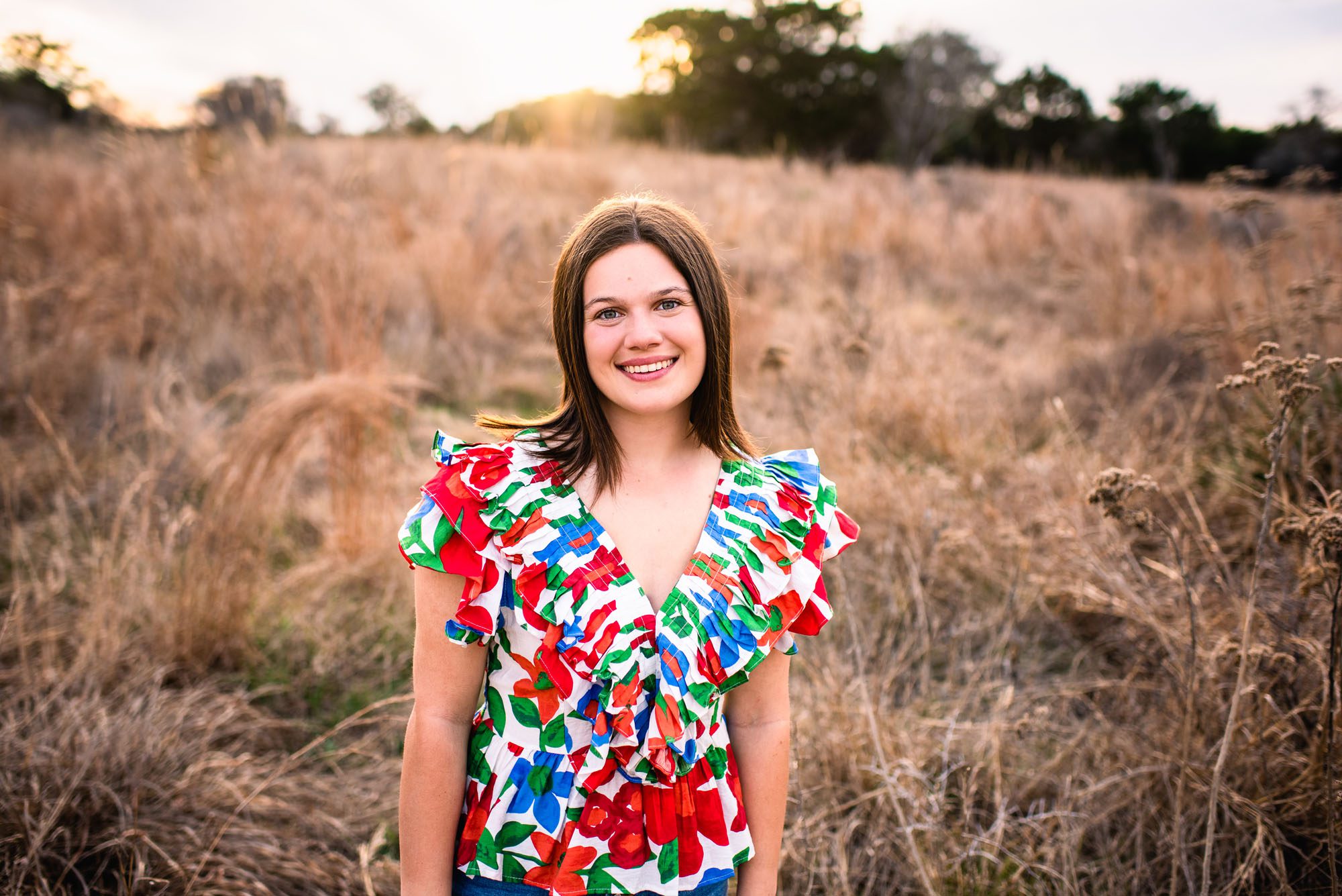 Senior girl smiling in a field at sunset, San Antonio senior photographer