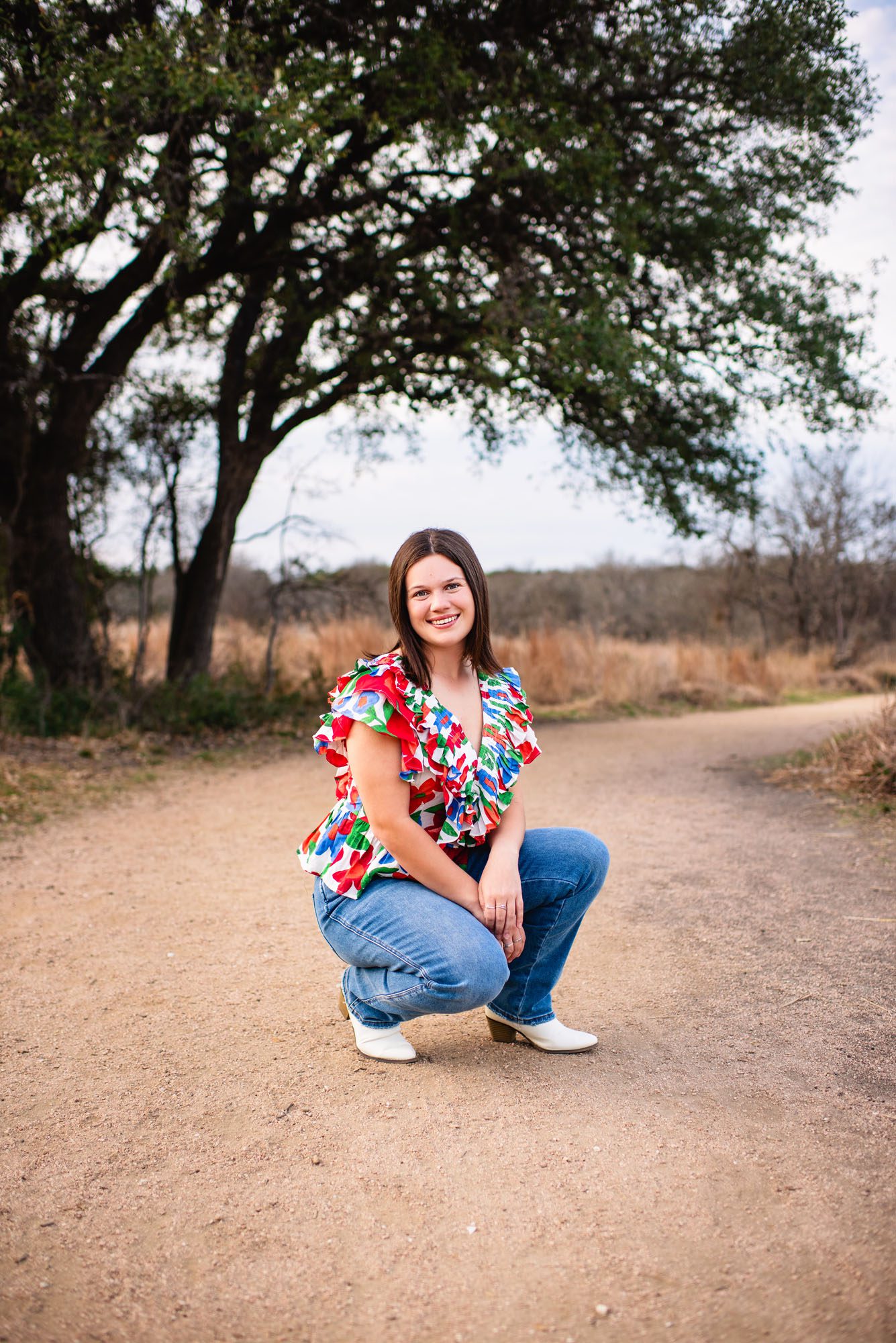 Senior girl in a brightly colored top under a tree, San Antonio senior photographer