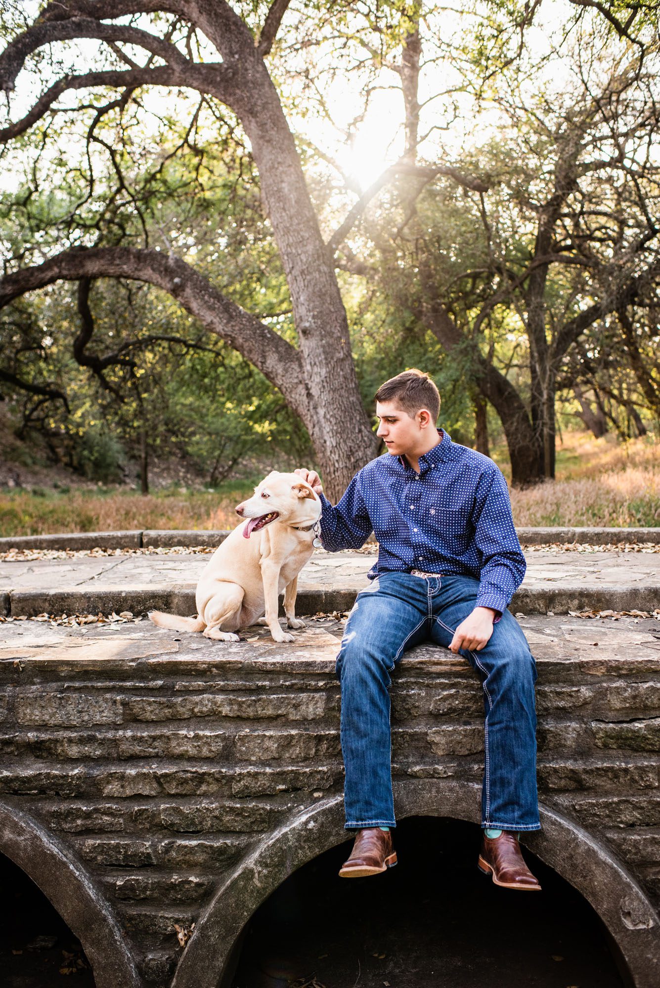 Boy sitting with his dog on a bridge, best San Antonio senior photographer