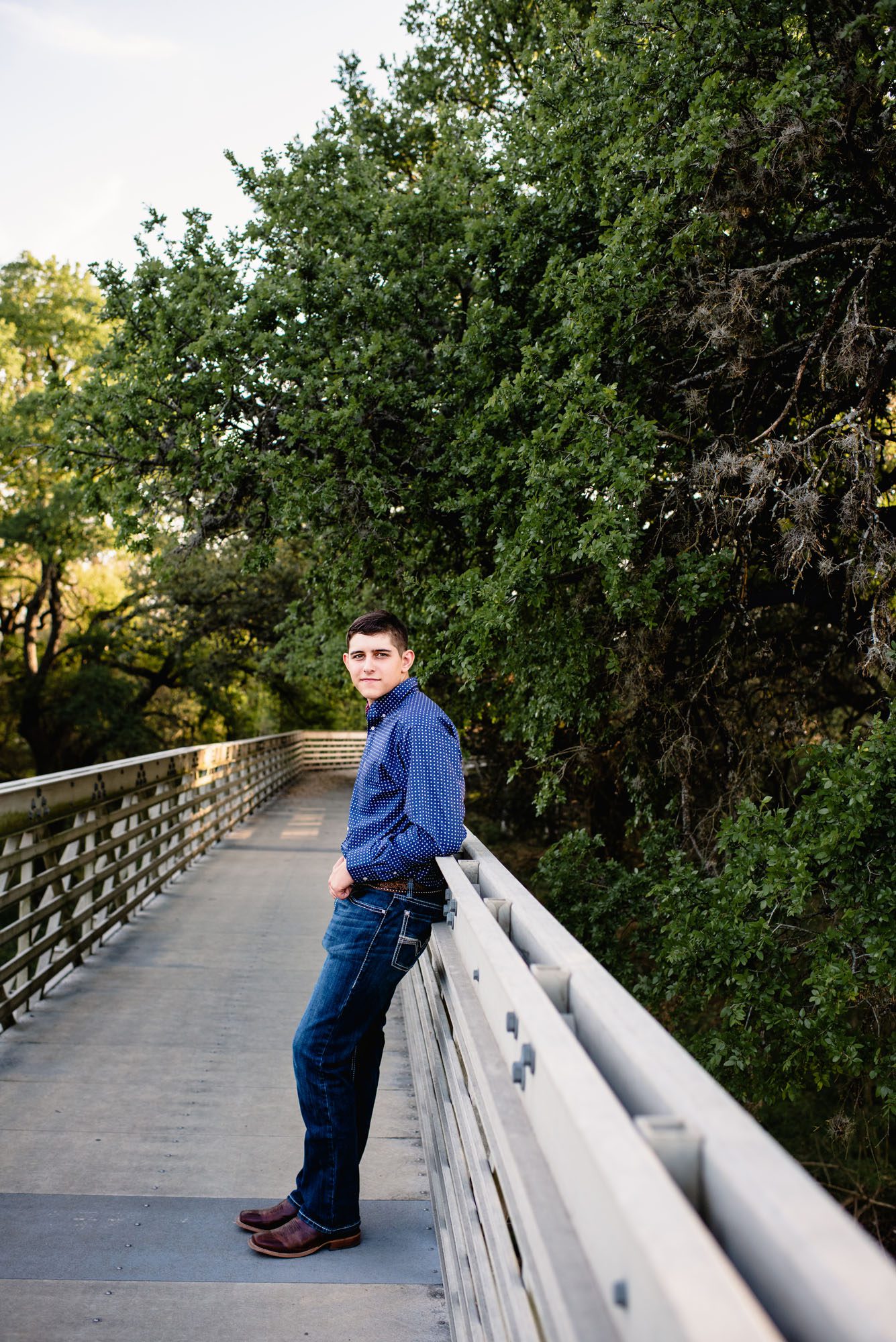 Boy leaning against a bridge, San Antonio senior portrait photographer
