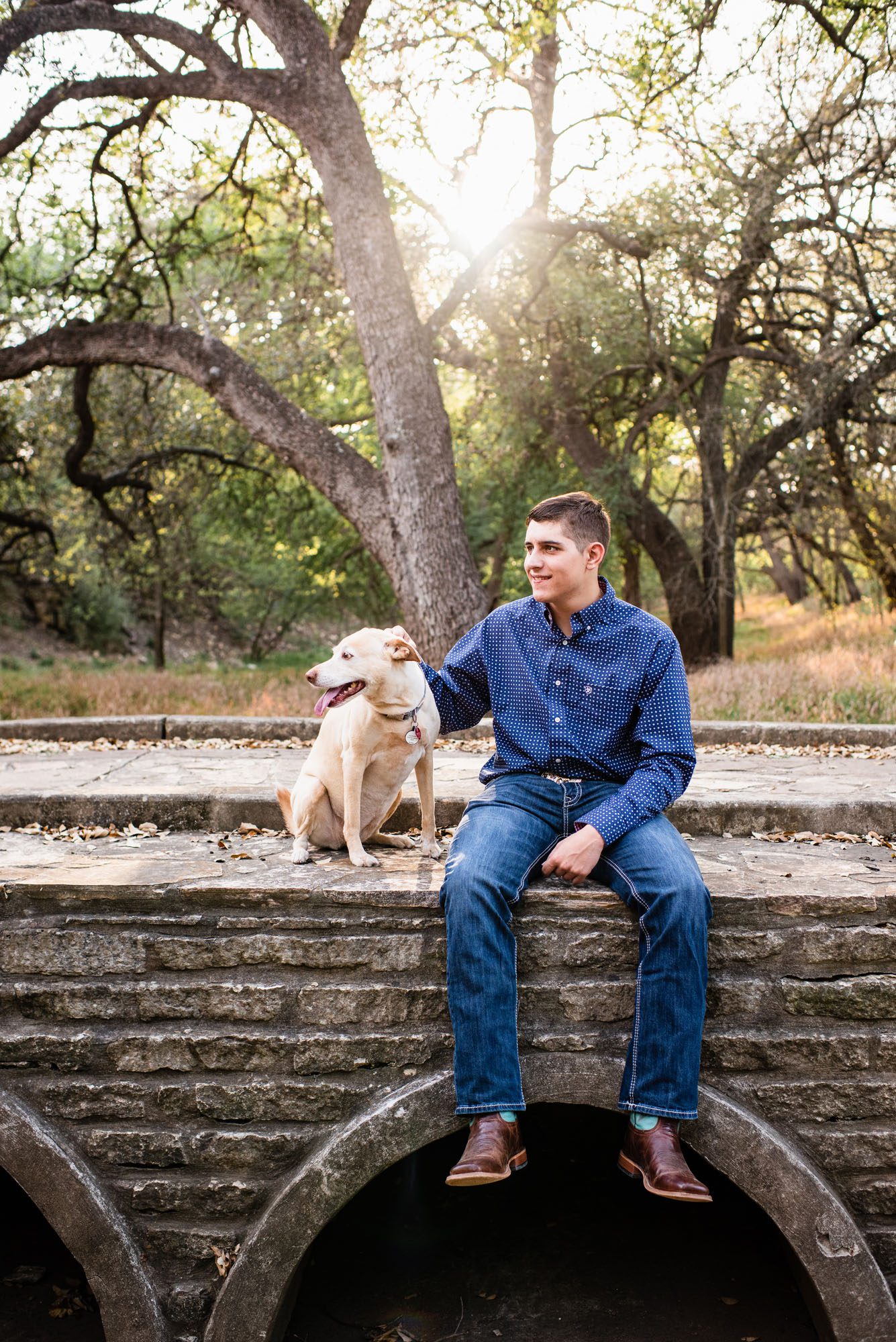 Boy sitting with his dog on a bridge, San Antonio senior portrait photographer