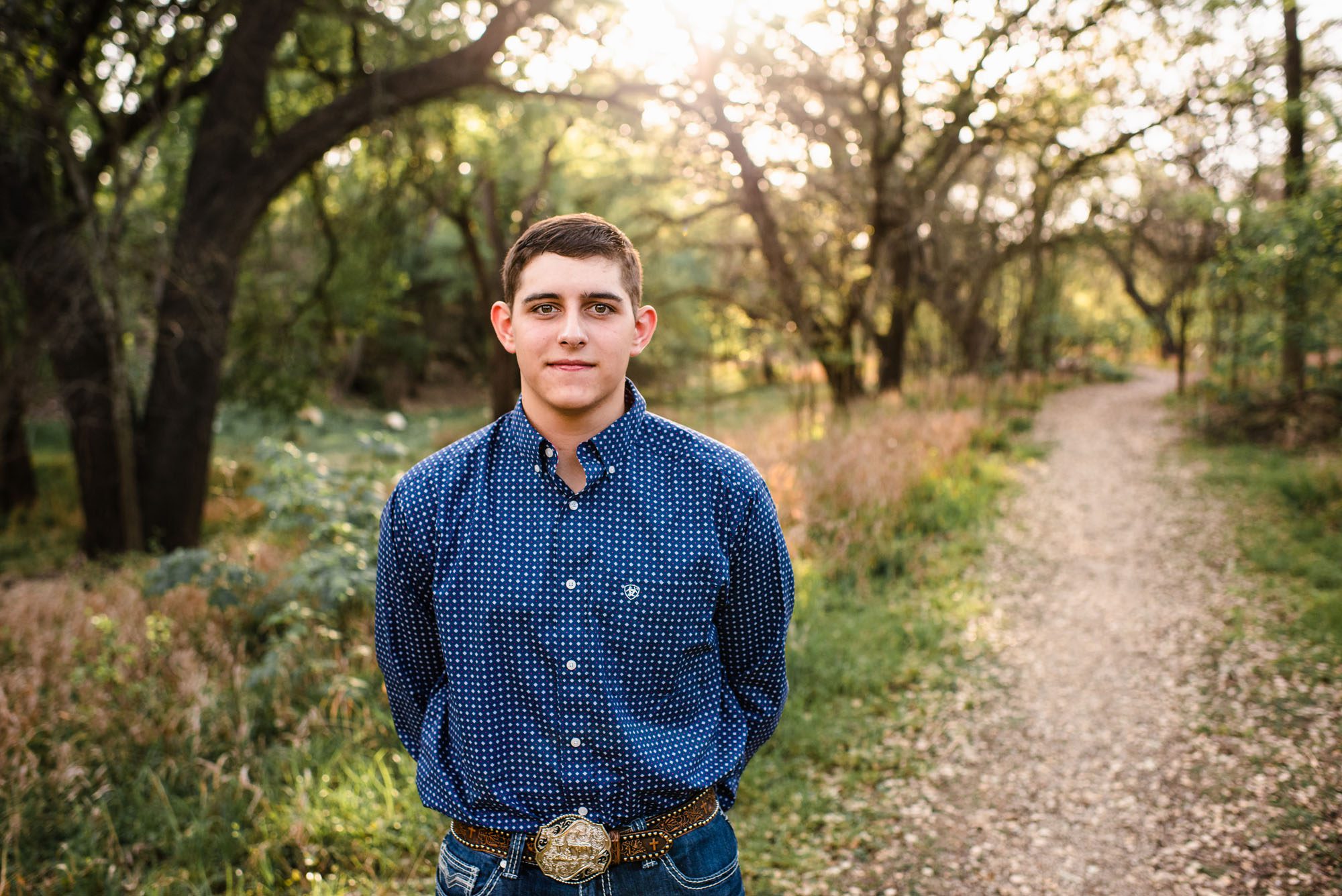 Bot standing in the woods by a walkway, San Antonio senior portrait photographer
