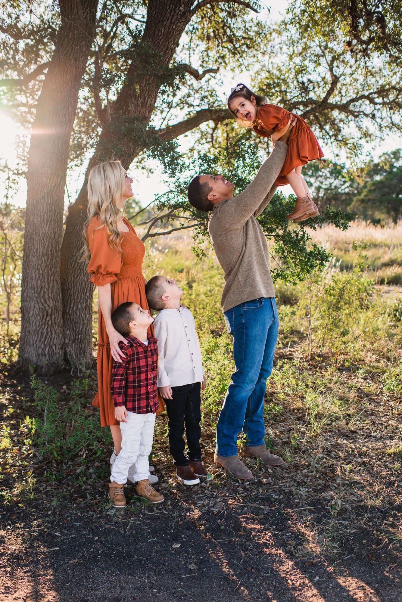 Dad holding up daughter under a tree, best family photographer in San Antonio
