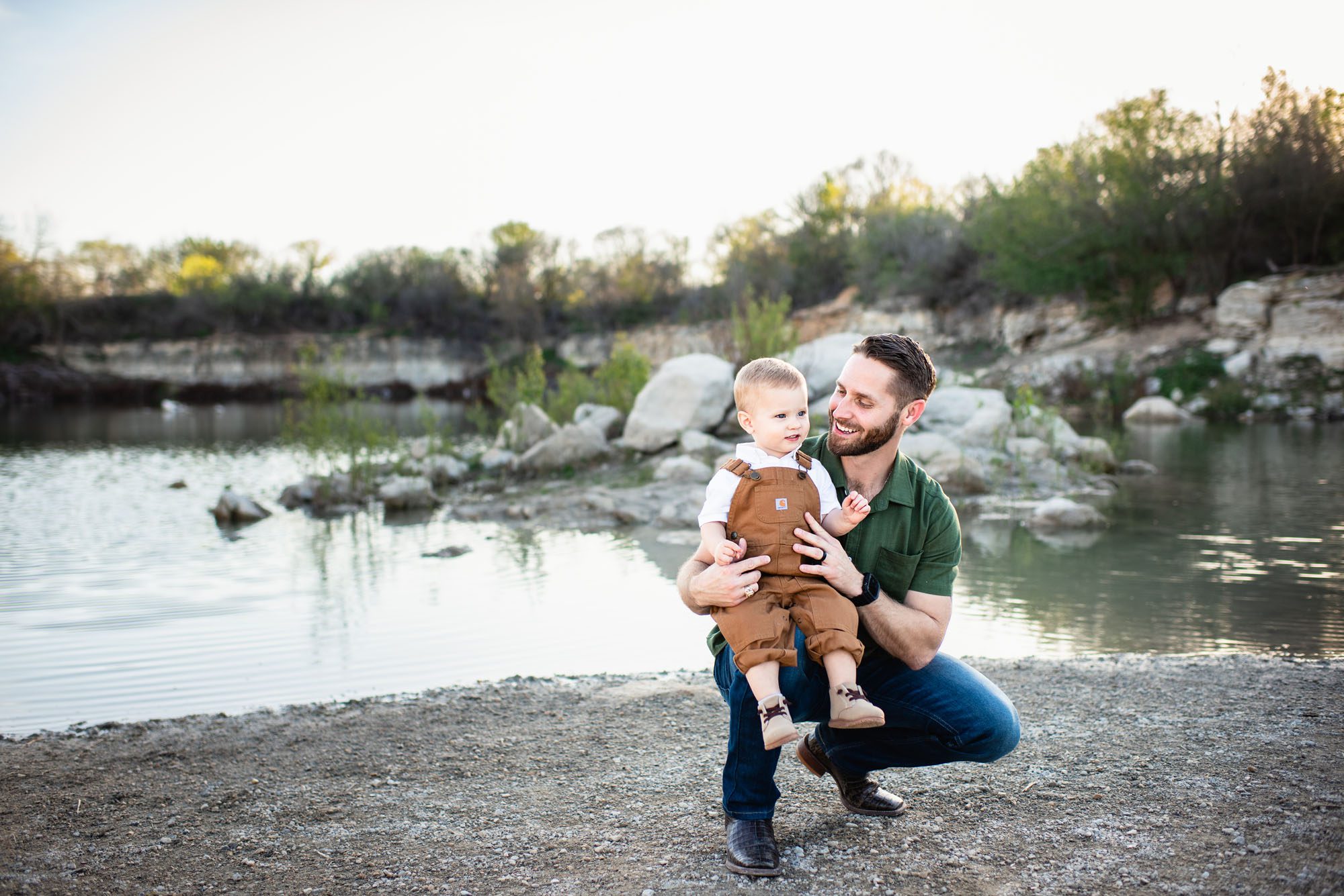 Father smiling at son by a lake at sunset, San Antonio family photographer