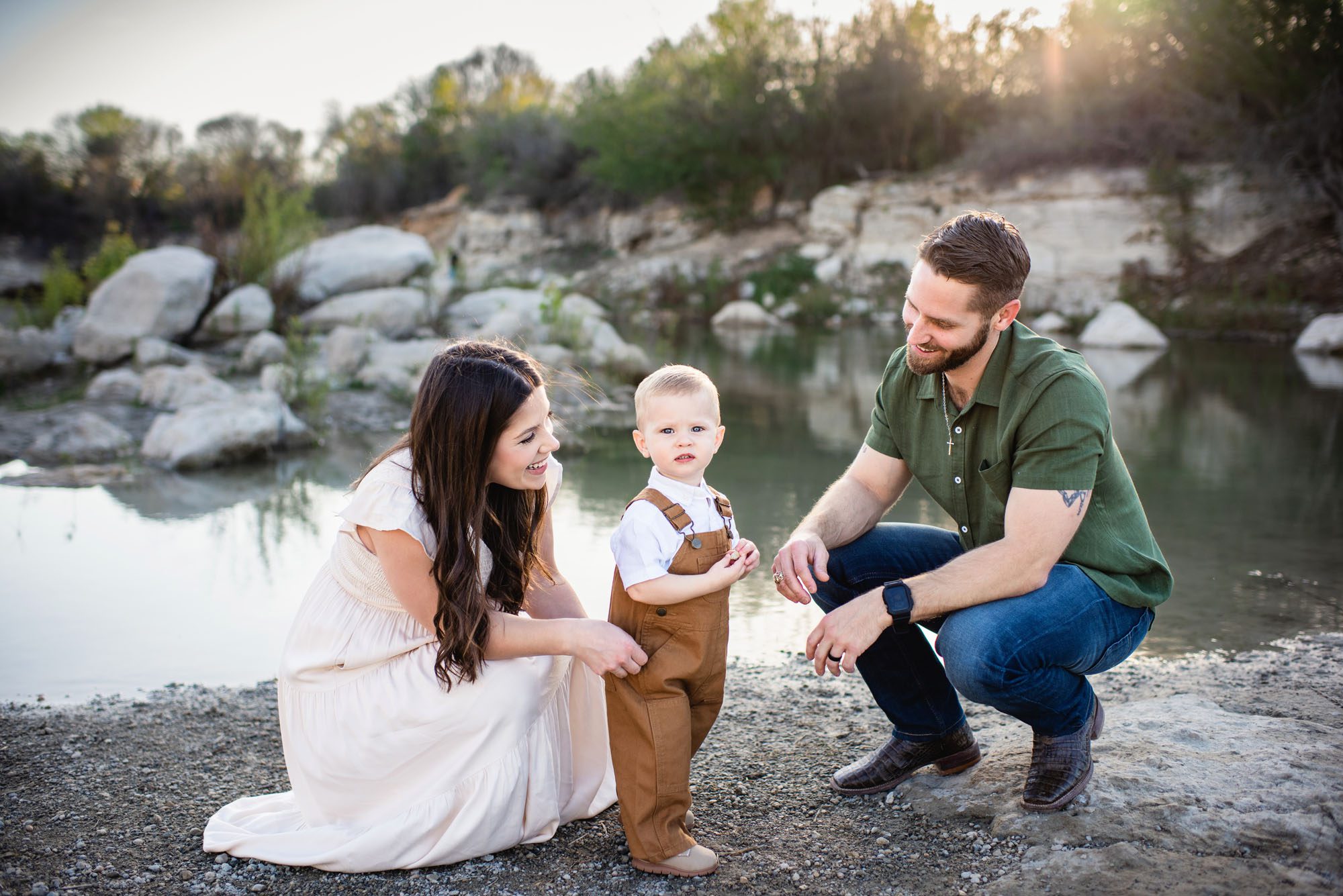 Parents squatting down by toddler son, San Antonio maternity photographer