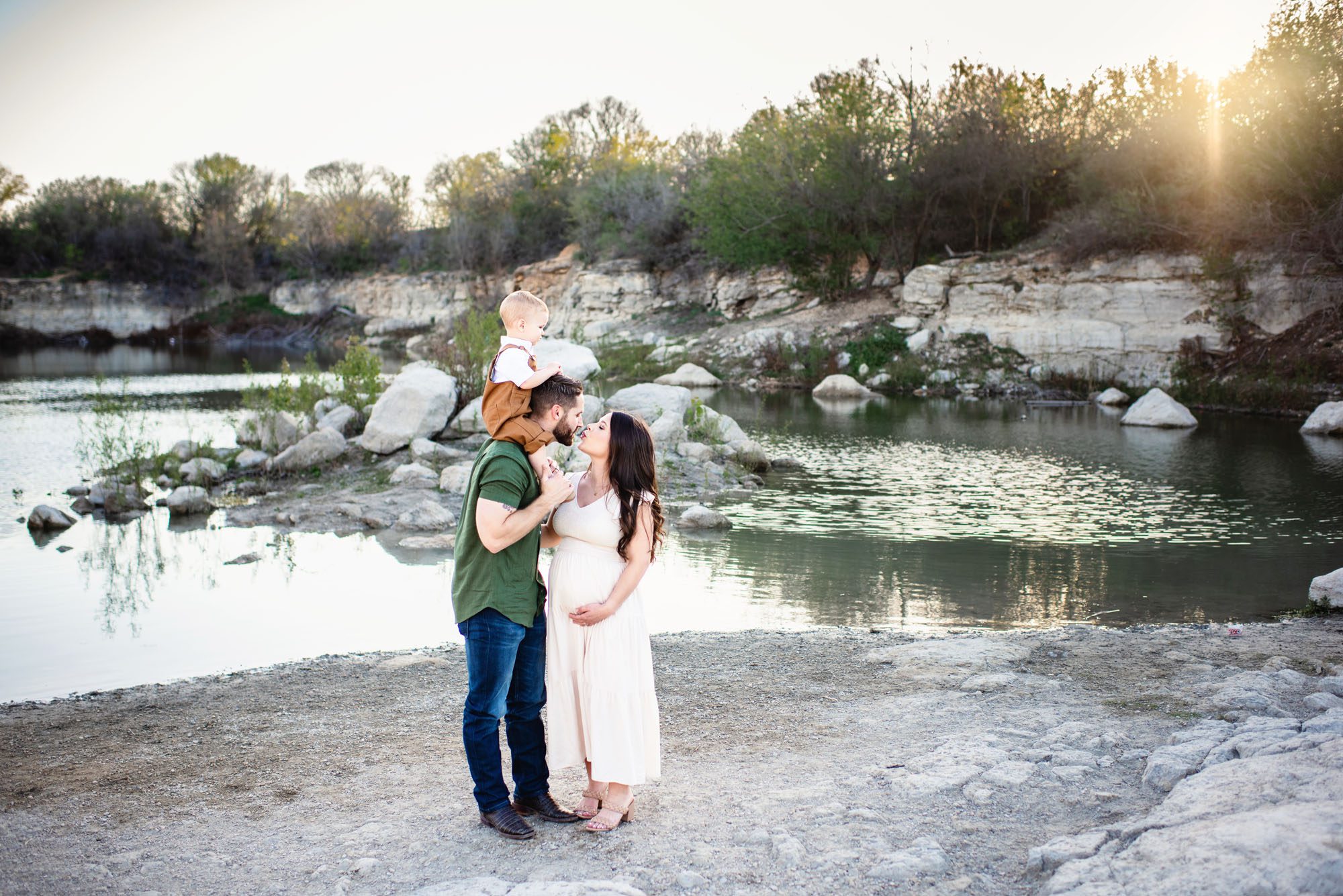 Family kissing by a lake at sunset, San Antonio maternity photographer