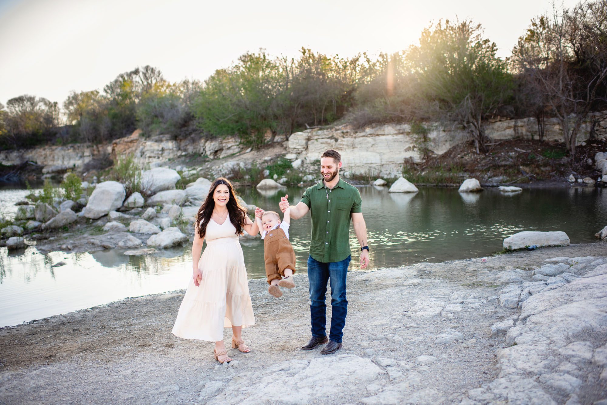 Pregnant mom smiling by a lake at sunset, San Antonio maternity photographer