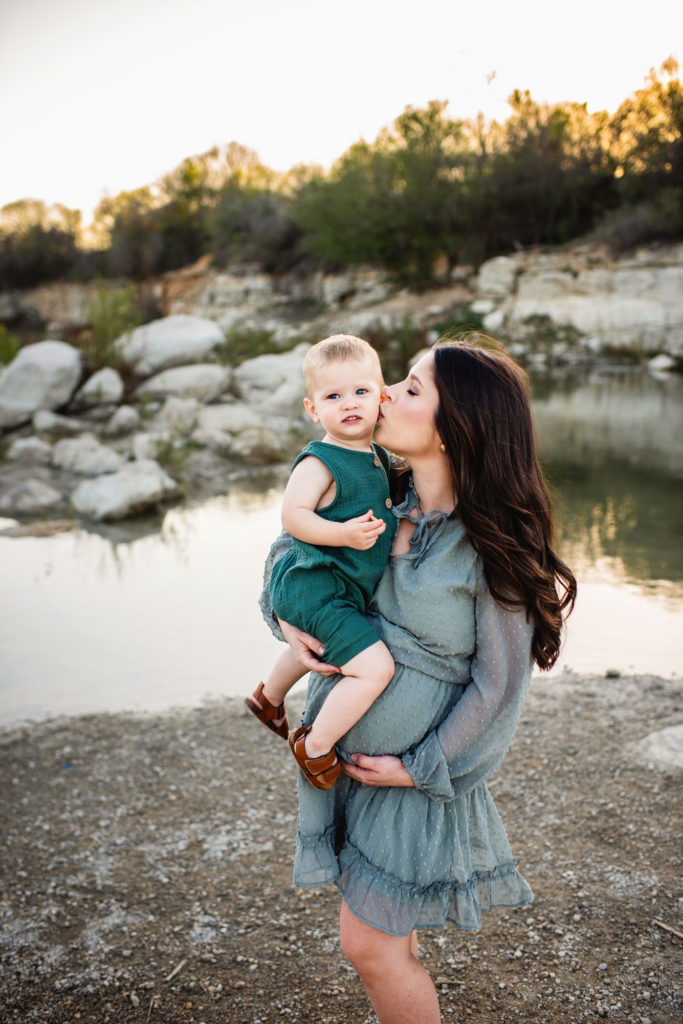 Mother kissing son by a lake, San Antonio lifestyle maternity photographer