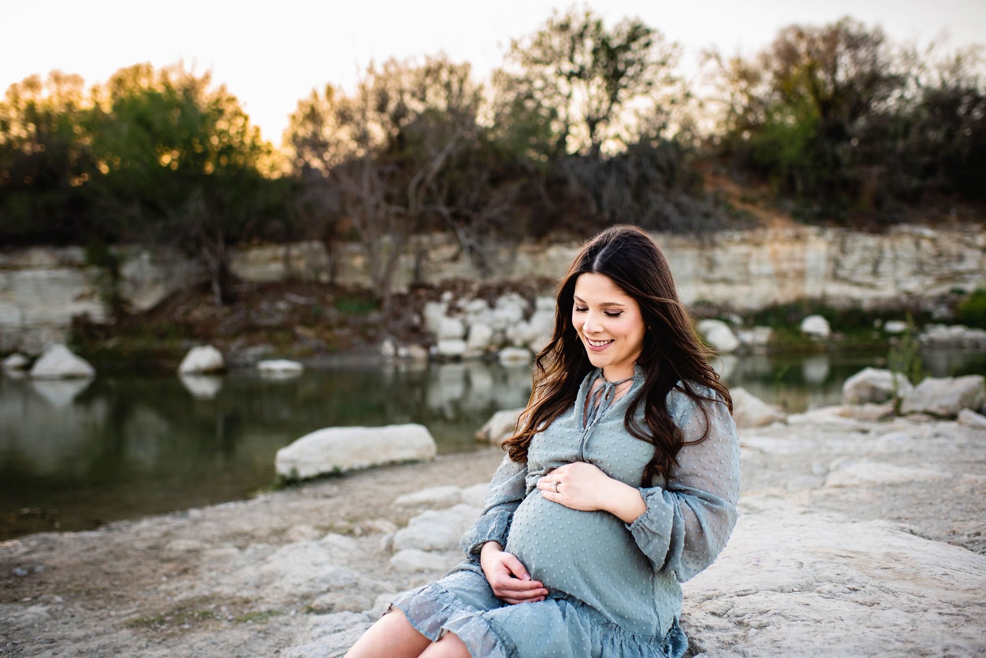 Mom smiling at her baby bump, Maternity photographer in San Antonio