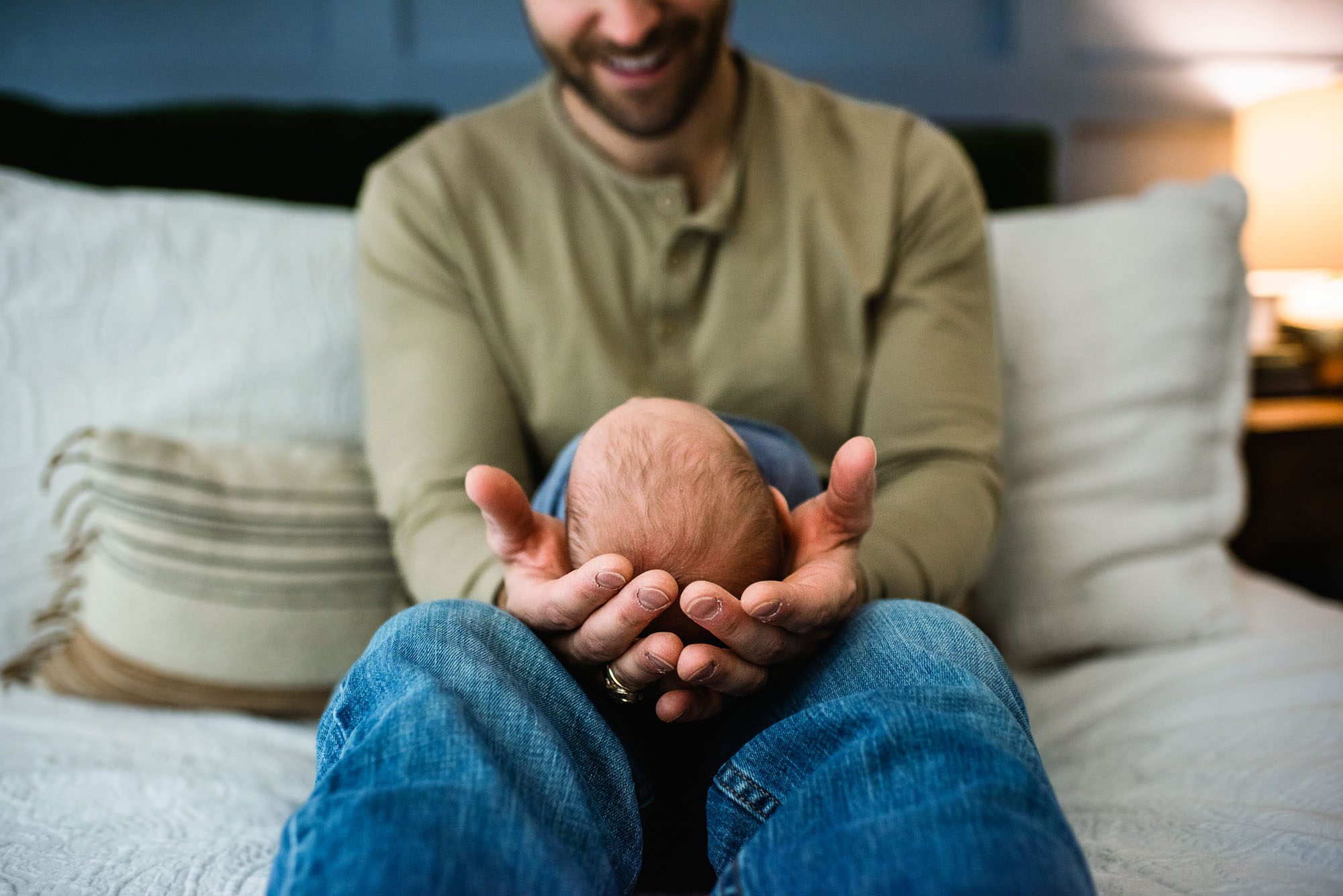 Dad holding newborn son in his lap, San Antonio lifestyle newborn photographer