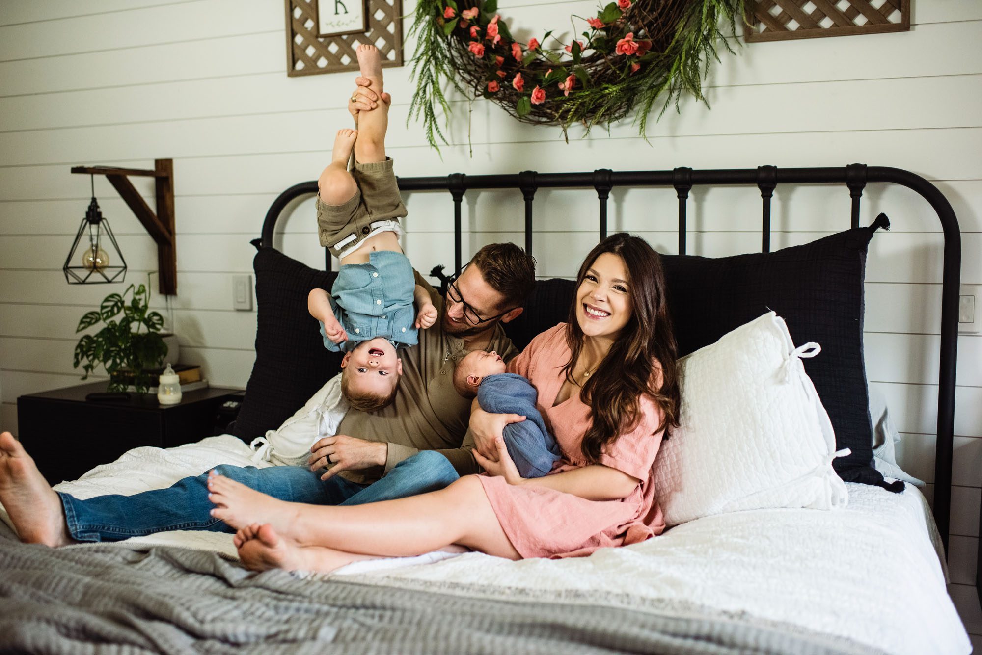 Family playing with toddler and newborn baby on bed, San Antonio newborn photographer