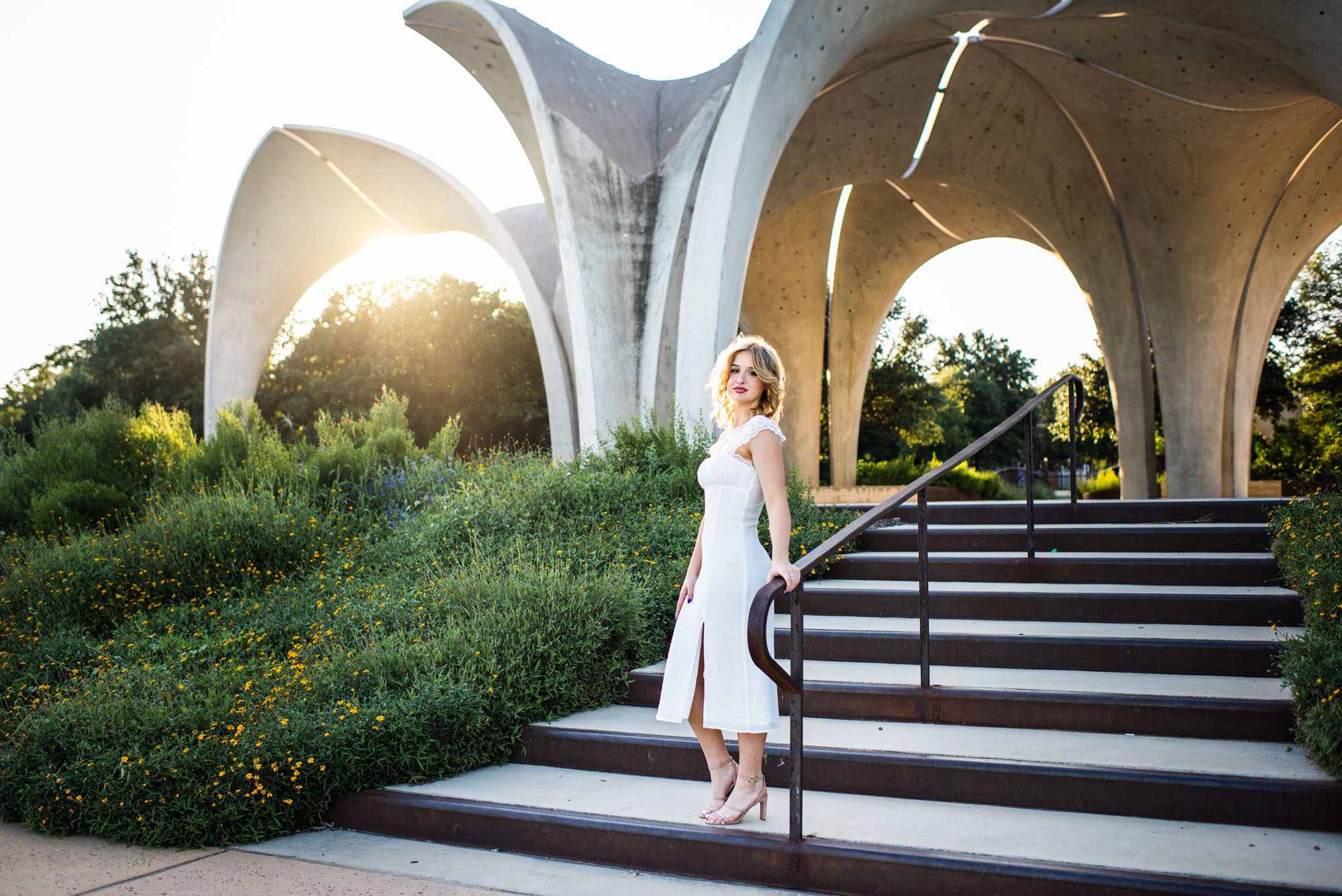 Senior girl in white dress standing by pavilion at sunset, San Antonio senior portraits