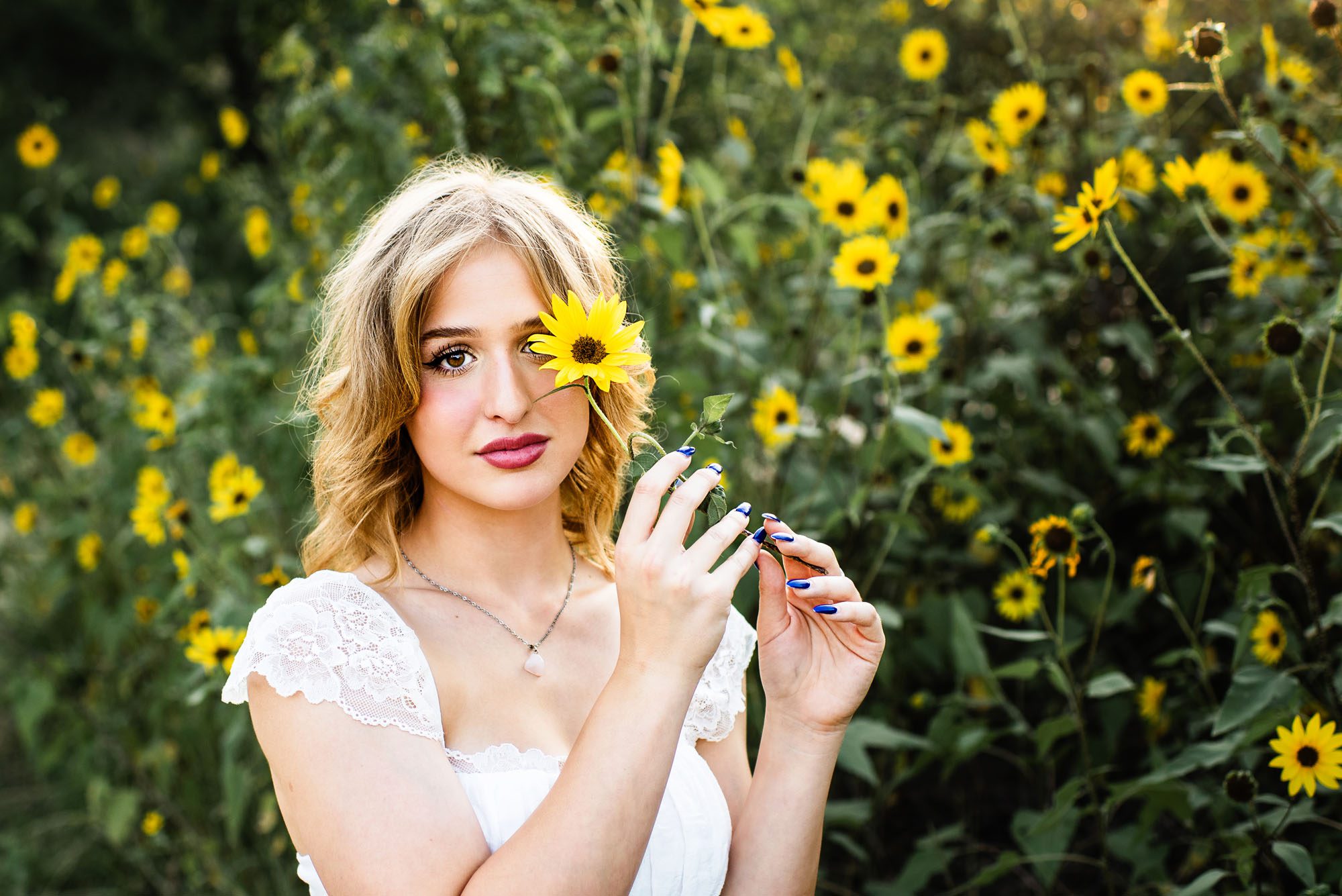 Girl holding sunflower over her eye, San Antonio senior photographer