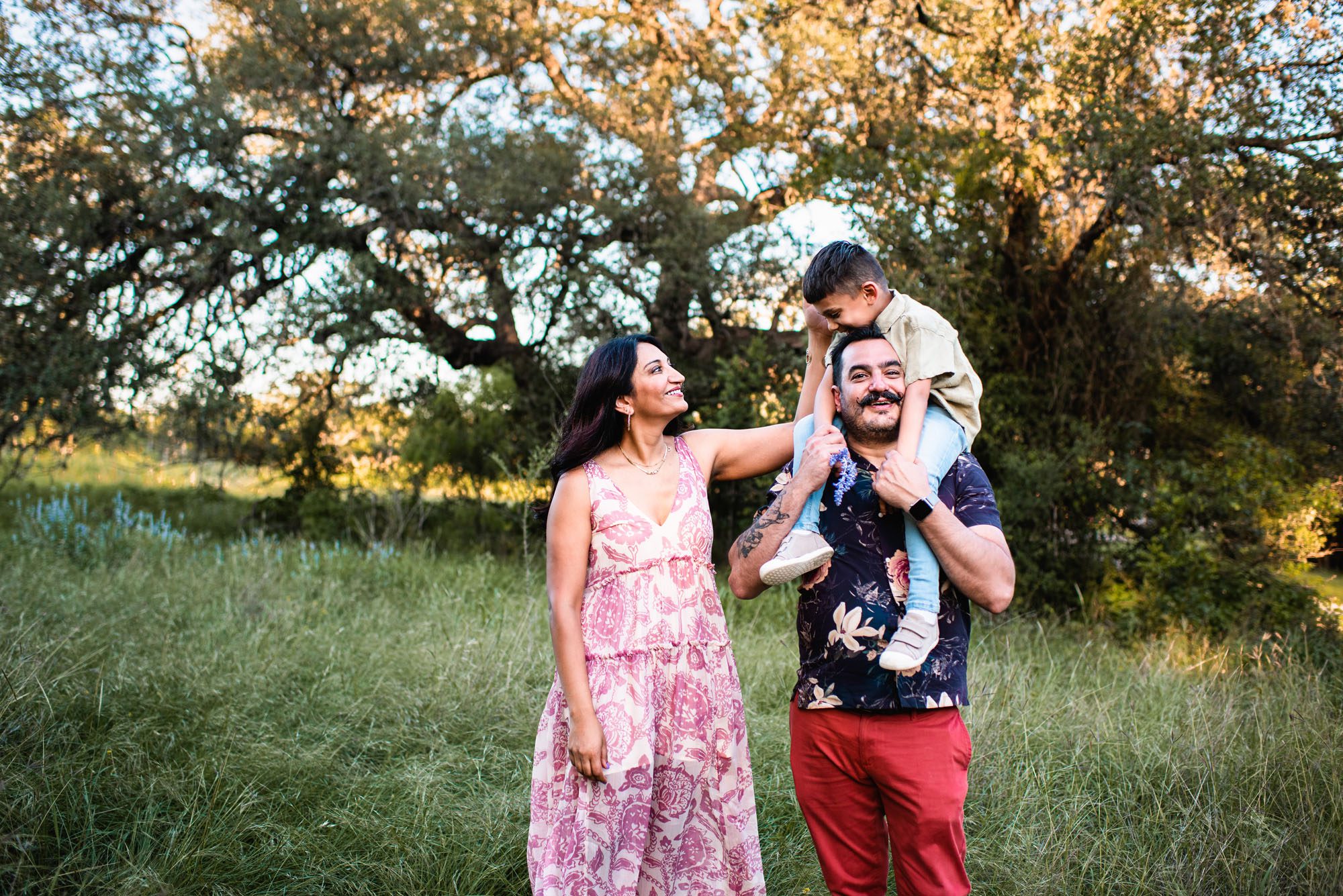 Family standing together in grassy field with oak trees, Family photographer in San Antonio
