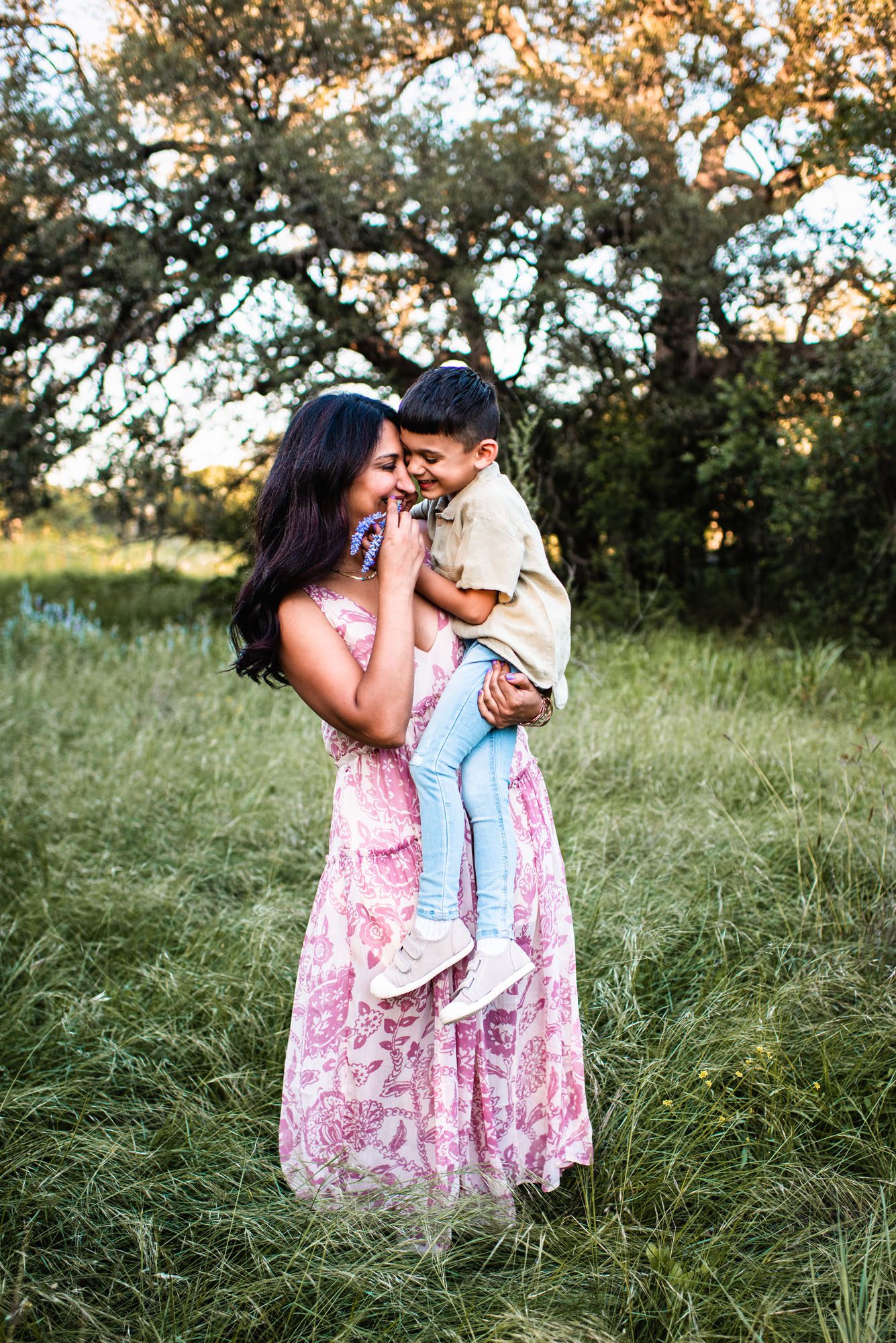 Mother and son hugging in grassy field, Family photographer near me