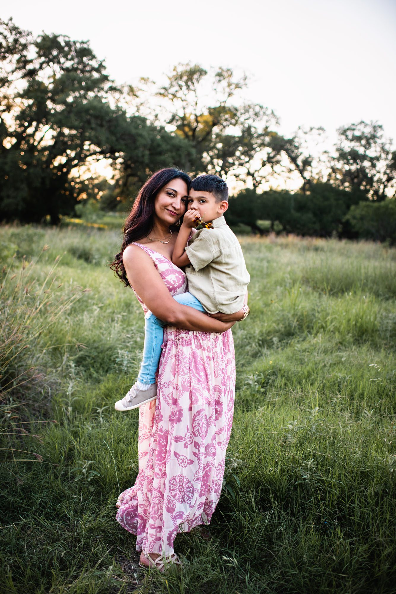 Mother and son hugging in grassy field, San Antonio family photographer