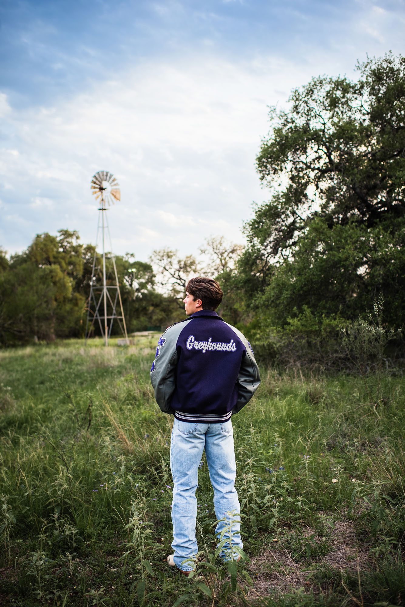 Boy standing in field with windmill, San Antonio senior photographer