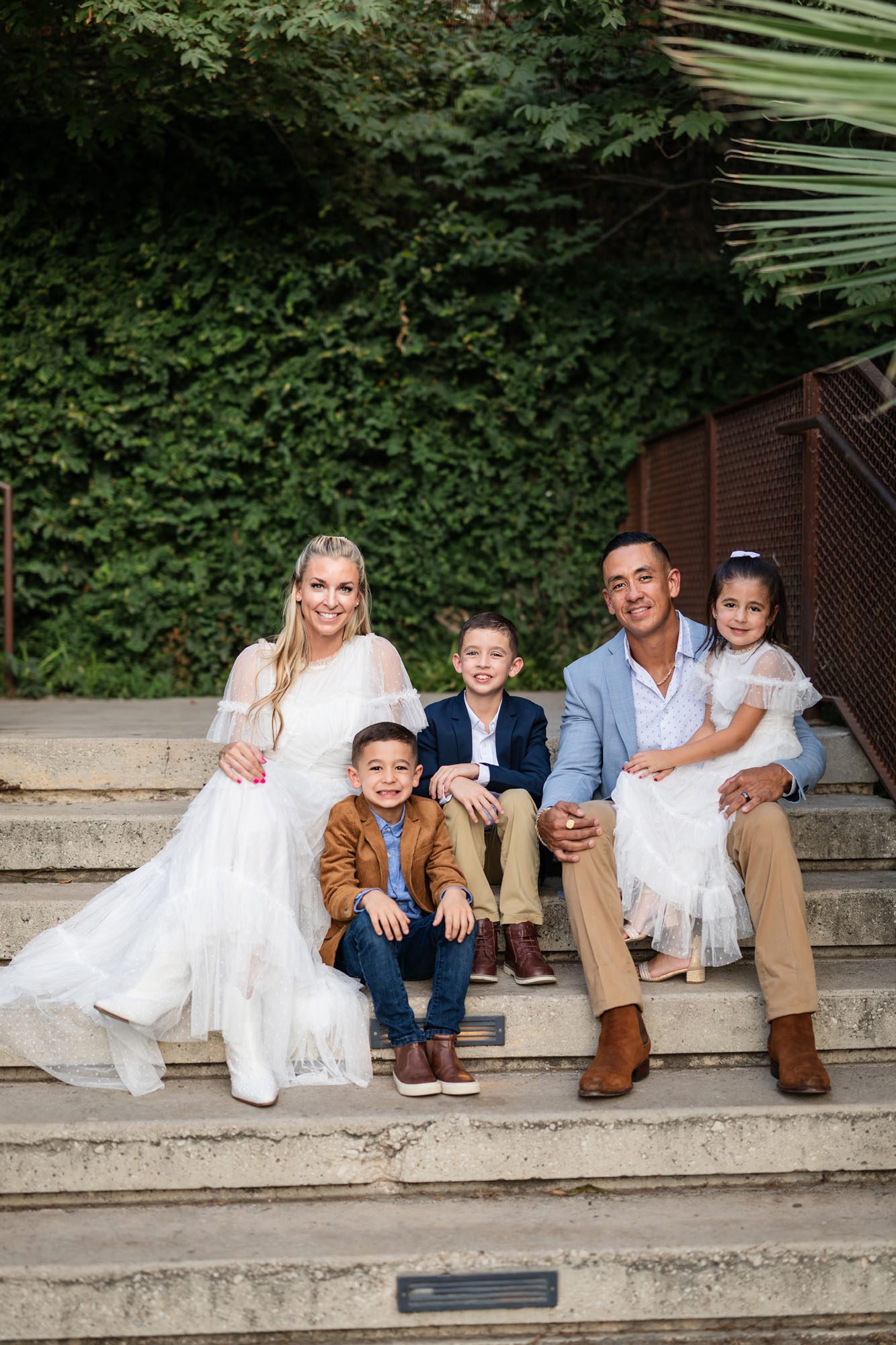 Family sitting together on steps, family photographer in San Antonio