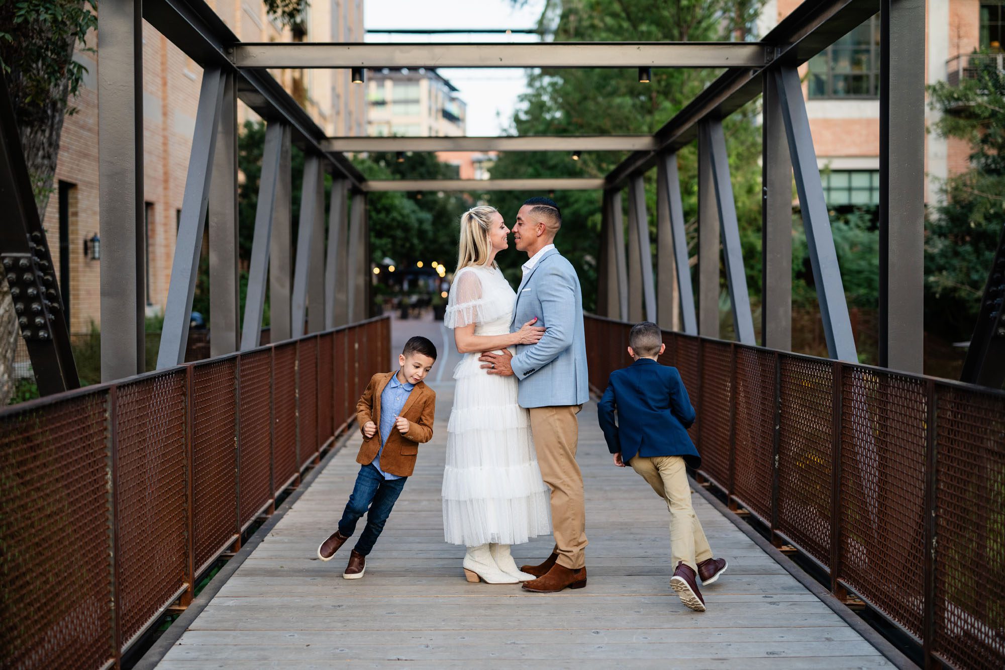 Couple smiling at each other while kids run around them, San Antonio family photographer