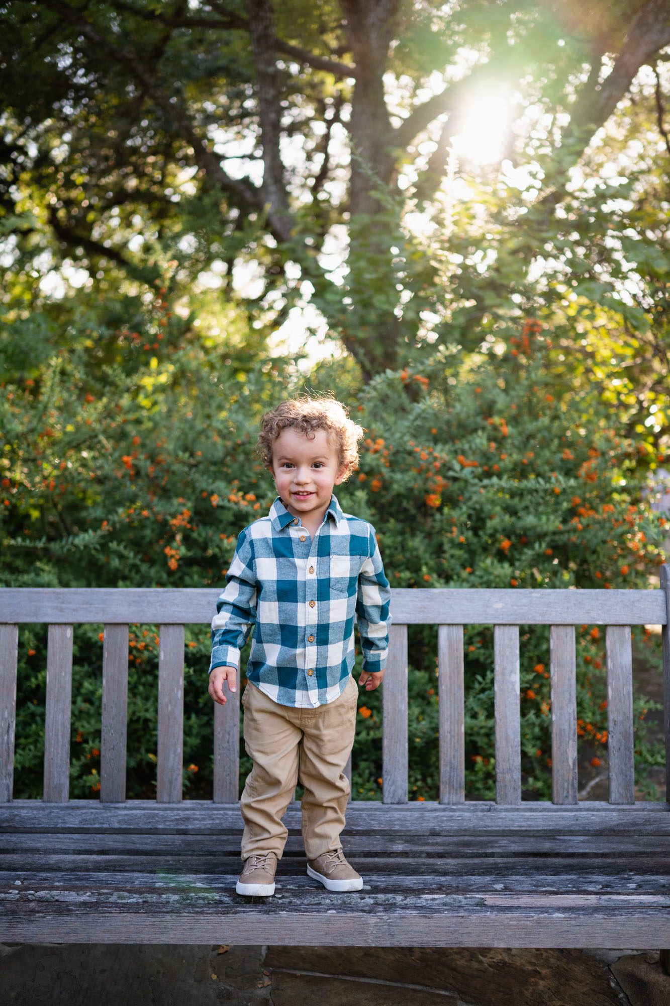 Little boy standing on bench with sun behind him, San Antonio family photographer