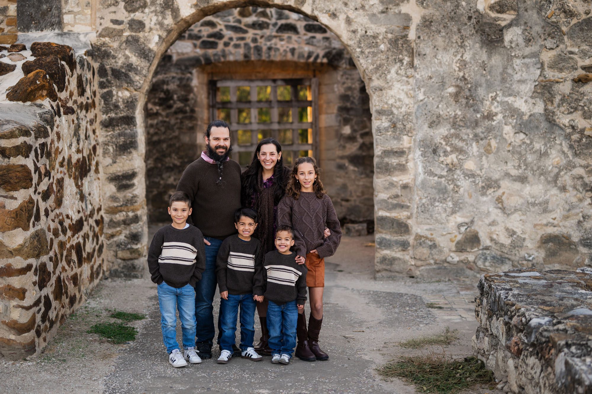 Family of six in stone archway; San Antonio family photographer
