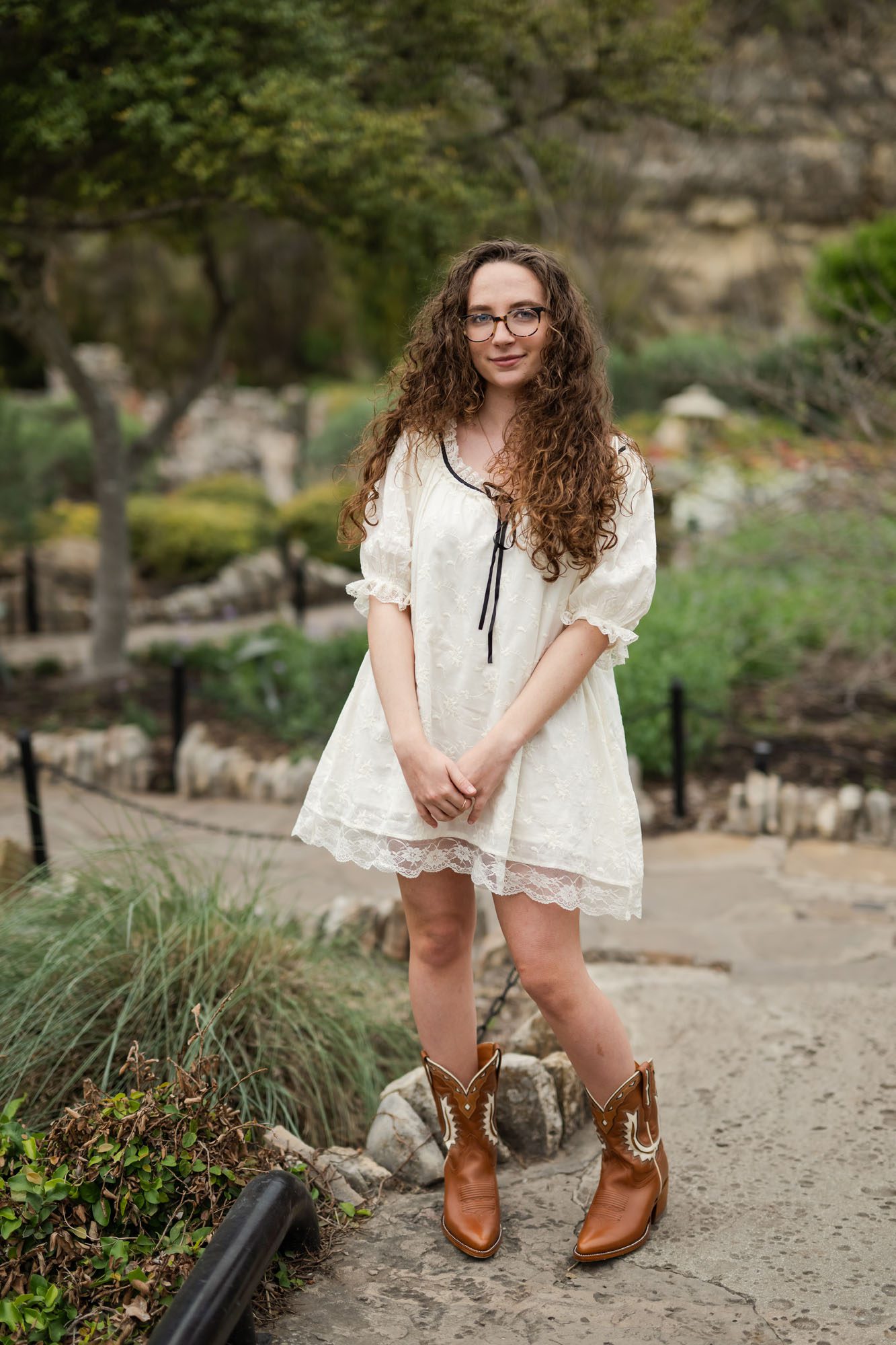 Girl in white dress standing in garden, San Antonio senior photographer