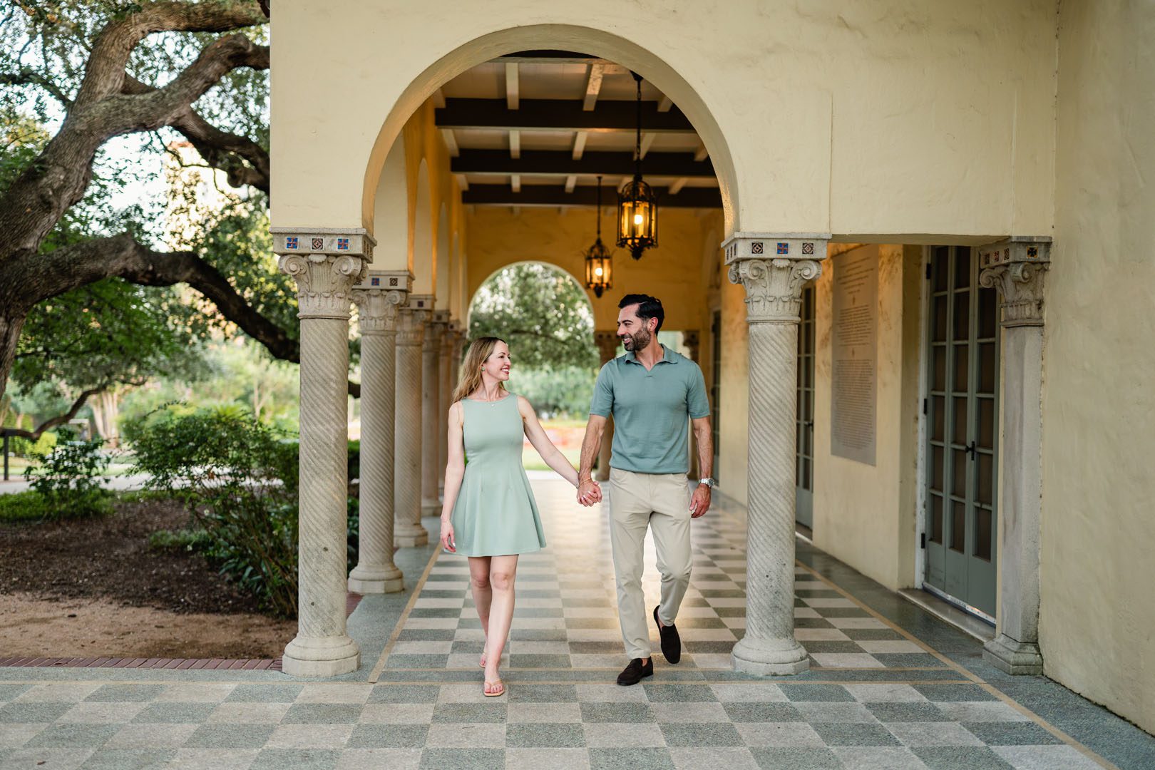 Couple walking hand-in-hand under archway, San Antonio family photographer